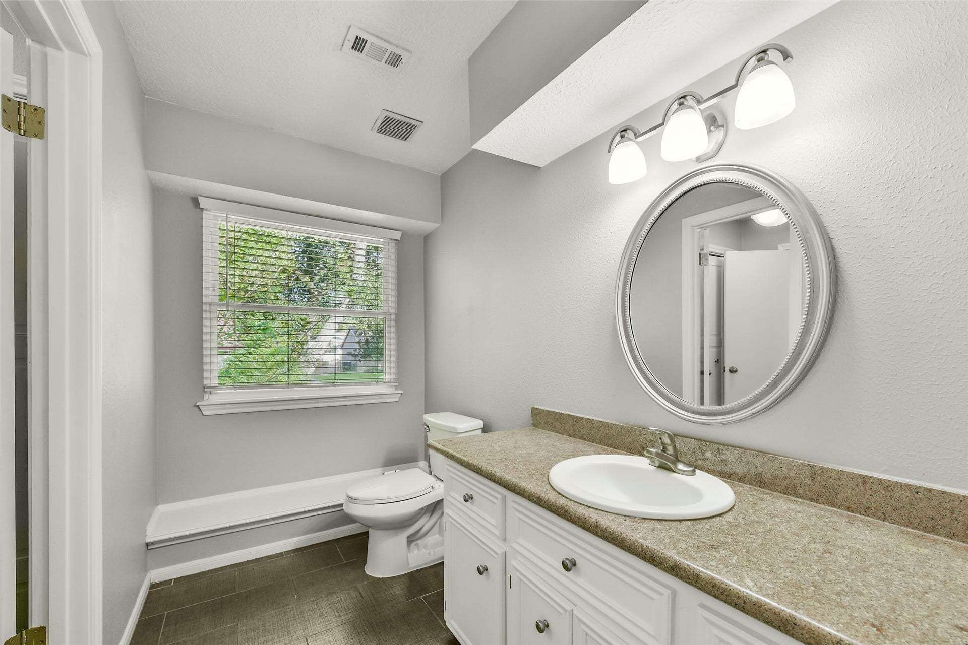 19611 Suncove Lane, Humble, TX 77346 Classic finishes meet everyday practicality. A tub-and-shower combination with subway-style tile and a contrasting accent band offers flexibility for a quick rinse or a relaxing soak, with the vanity just beyond.