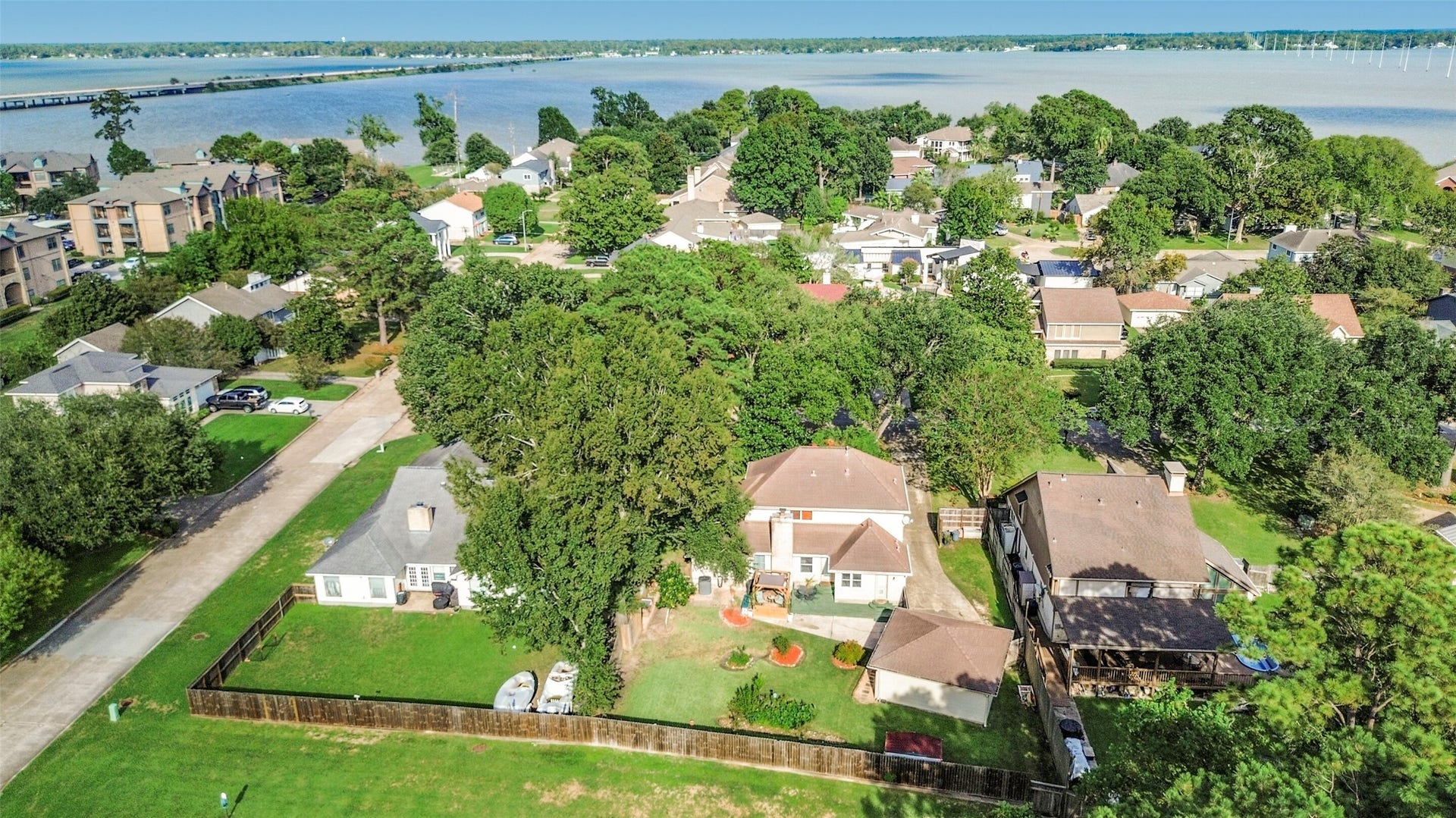 19611 Suncove Lane, Humble, TX 77346 A little breathing room with the lake close by. Access the community park and the community canal right from your back gate! This aerial view captures the generous backyard and established, tree-filled surroundings while revealing the nearby water that makes this setting especially appealing.