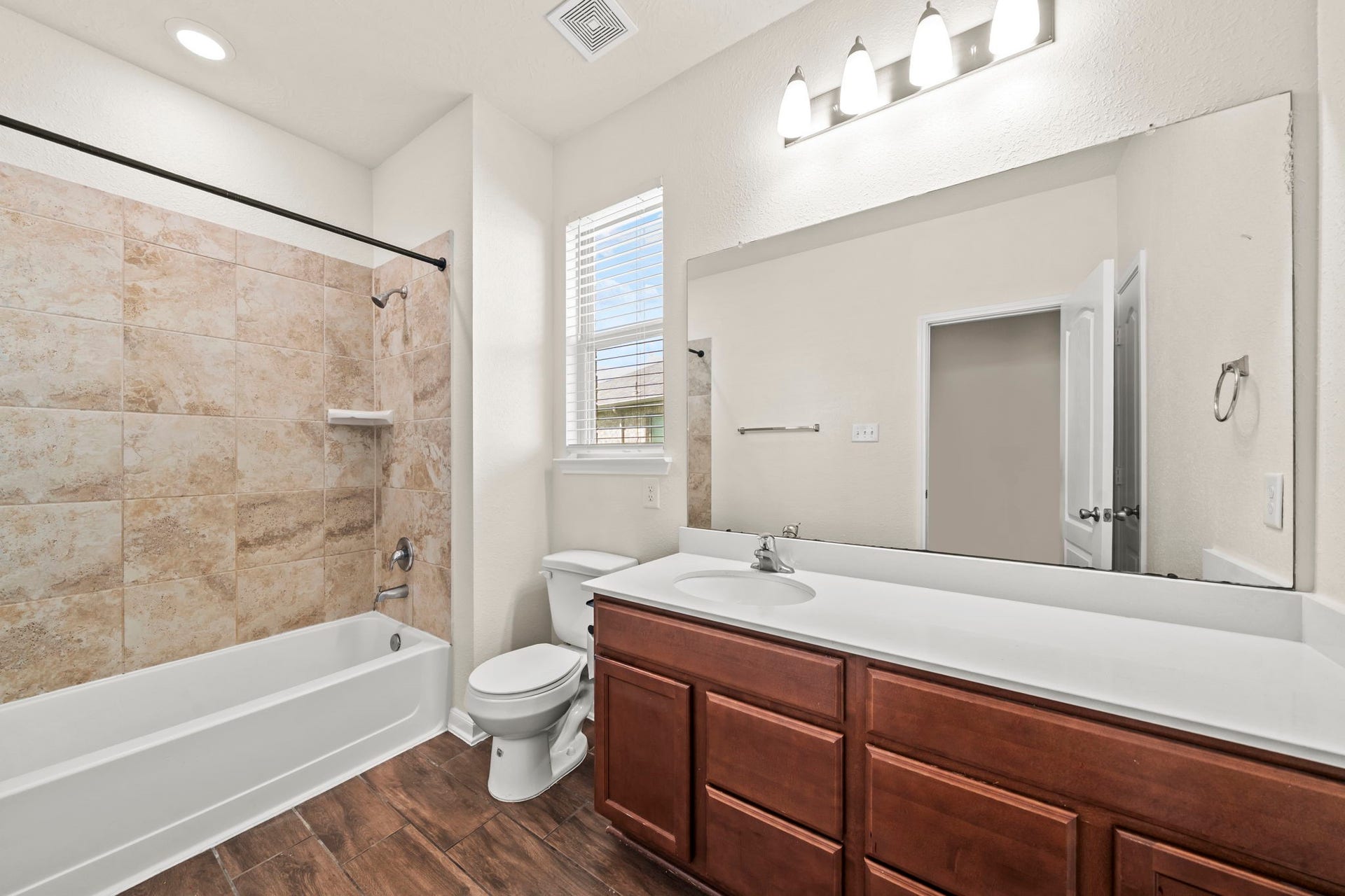 8908 Bear Mountain Court, Magnolia, TX 77354 Full secondary bath offering a extended single-sink vanity, wood cabinetry, and wood-look tile flooring.