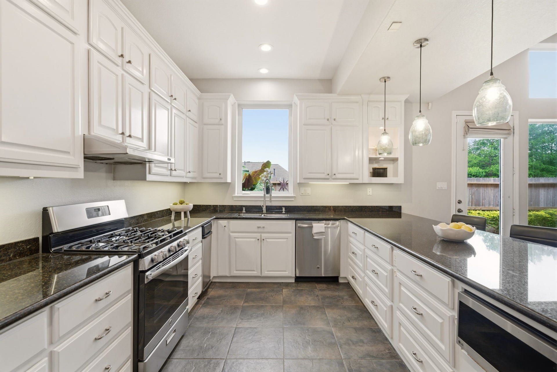 412 Live Oak Lane, Friendswood, TX 77546 Kitchen: enhanced by a large layout, it offers tons of storage and cabinetry alongside views of the bright, open living spaces.