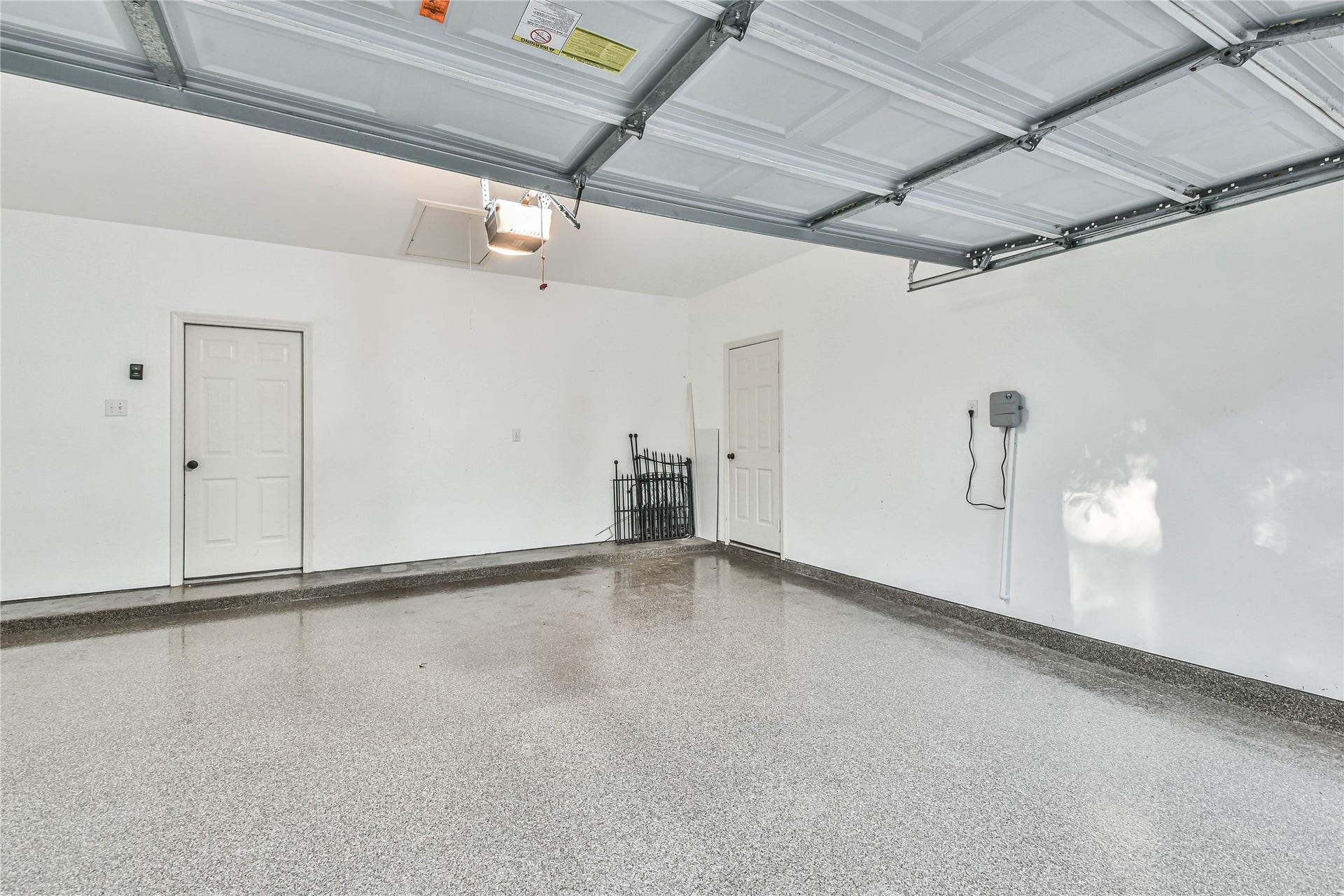 109 N Acacia Park Circle, The Woodlands, TX 77382 Two car garage with epoxy flooring and sprinkler system control panel.
