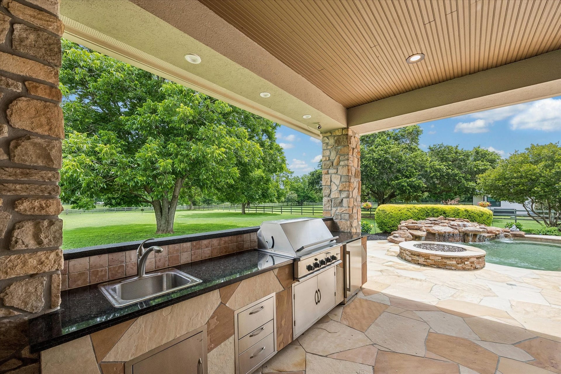 32102 Fulbrook Commons, Fulshear, TX 77441 Complete with built-in grill, sink, refrigerator, and generous prep space, the outdoor kitchen makes hosting family and friends effortless.