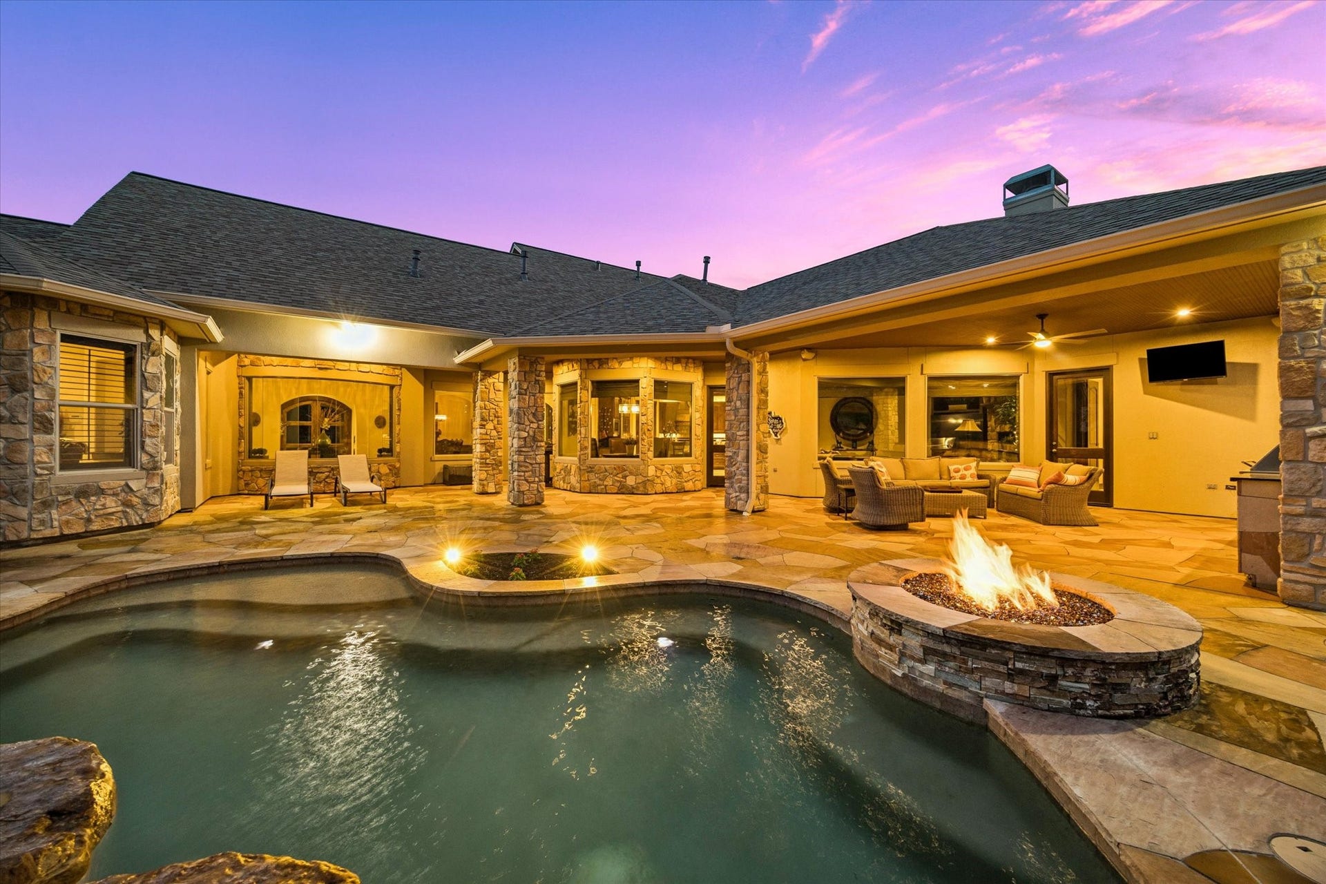 32102 Fulbrook Commons, Fulshear, TX 77441 The sparkling heated spa pool, fire feature, and expansive covered patio create an unforgettable setting for evening entertaining or peaceful relaxation.