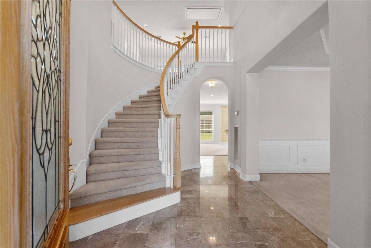 4402 Santee Drive, Baytown, TX 77521 Grand two-story foyer featuring polished tile flooring and a sweeping curved staircase.
