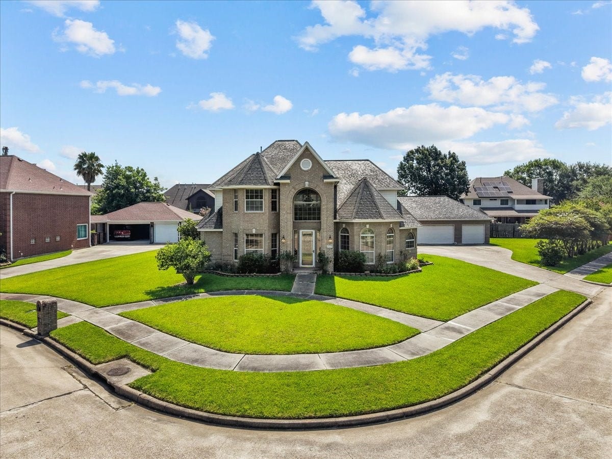 4402 Santee Drive, Baytown, TX 77521 Prominently positioned on a curve with wrap-around sidewalks, this stately two-story home offers an impressive arched entryway.