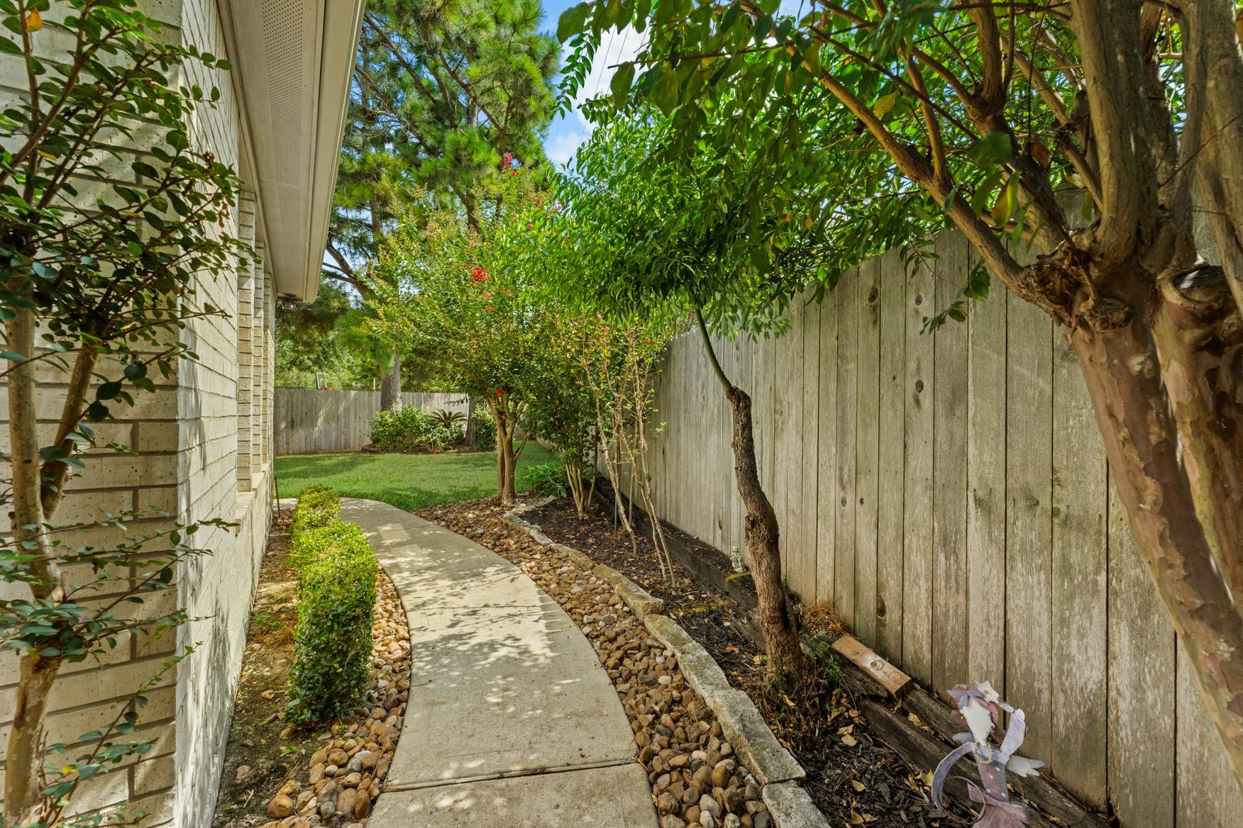 16503 Oat Mill Drive, Houston, TX 77095 A rock-lined pathway leads to the other side of the house.