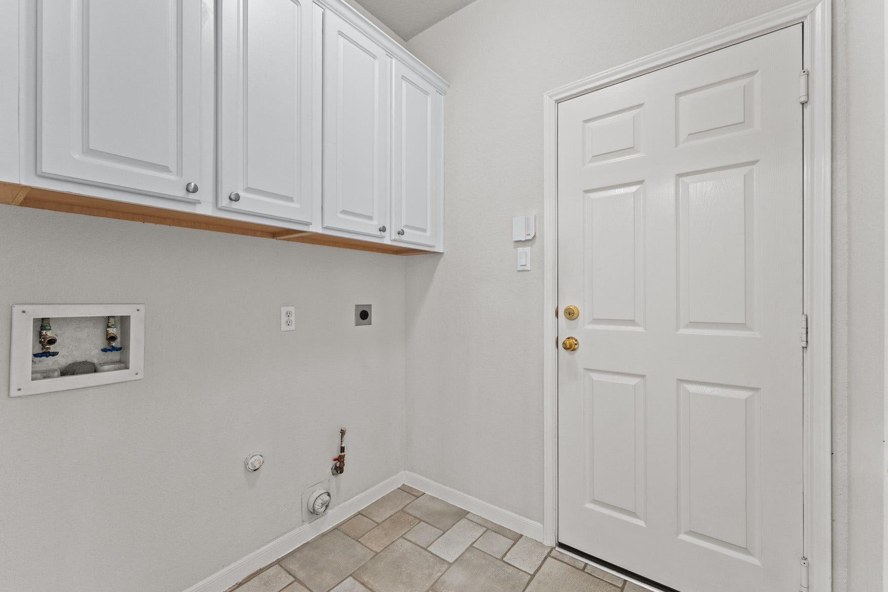 16503 Oat Mill Drive, Houston, TX 77095 Laundry room with storage cabinets and both gas and electric dryer connections.