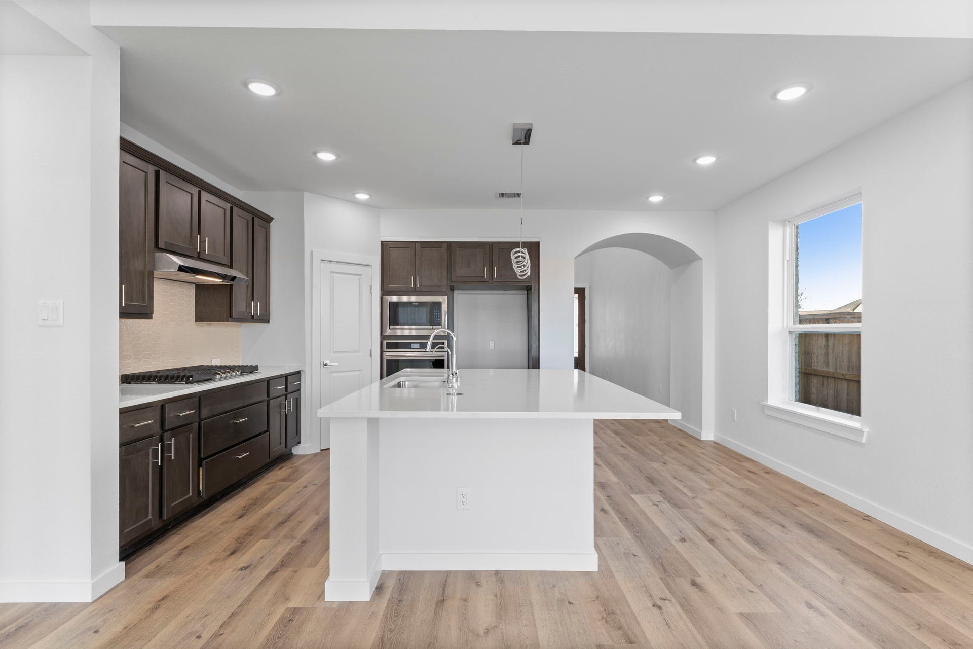 2230 Fresh Flower Way, Richmond, TX 77406 The massive center island serves as both a prep station and a social hub, featuring an undermount stainless steel sink and modern chrome fixtures.