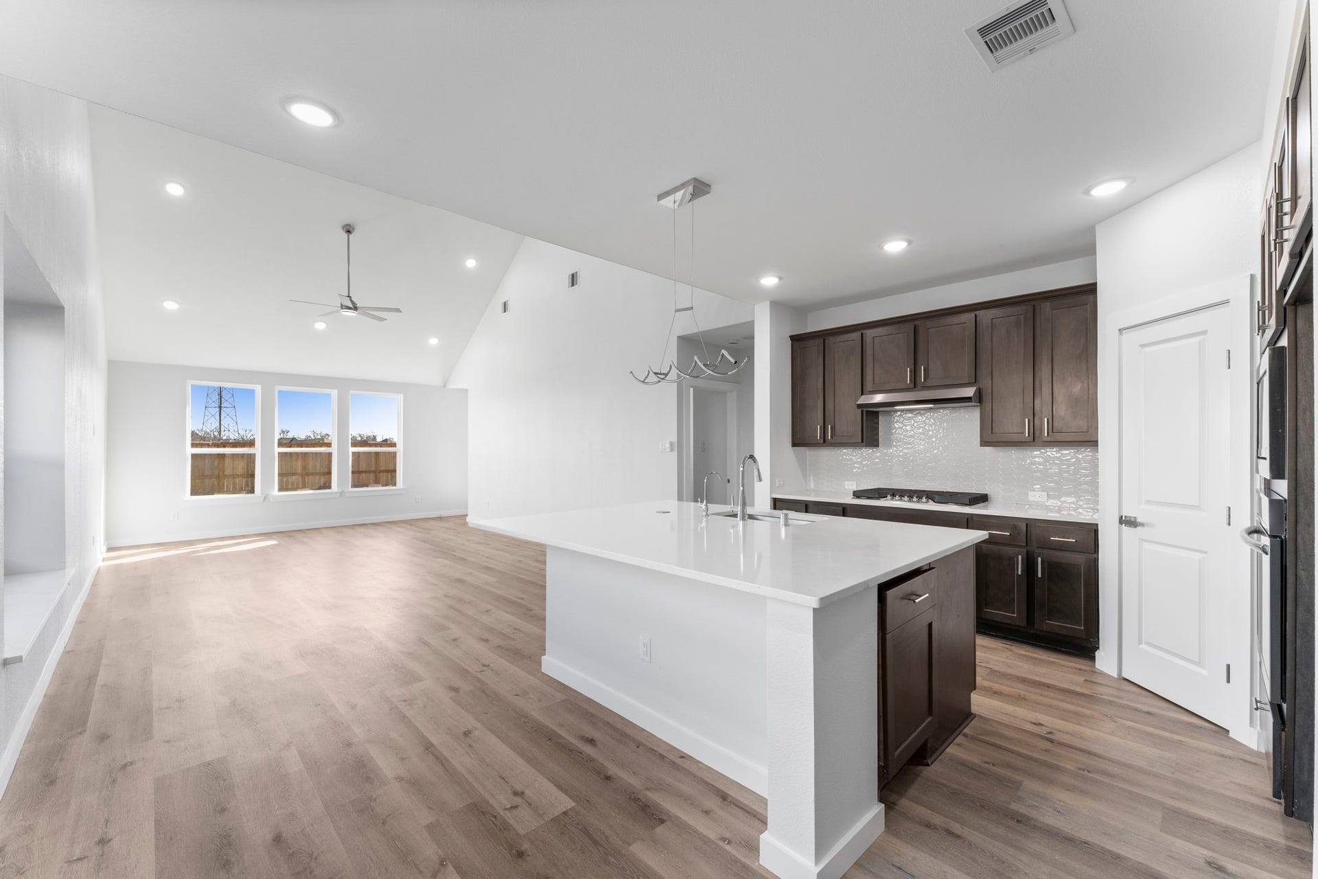 2230 Fresh Flower Way, Richmond, TX 77406 Experience the ultimate open-concept layout where the gourmet kitchen flows seamlessly into a sun-drenched living area. The soaring vaulted ceilings and expansive windows create an airy, grand atmosphere perfect for hosting large gatherings.