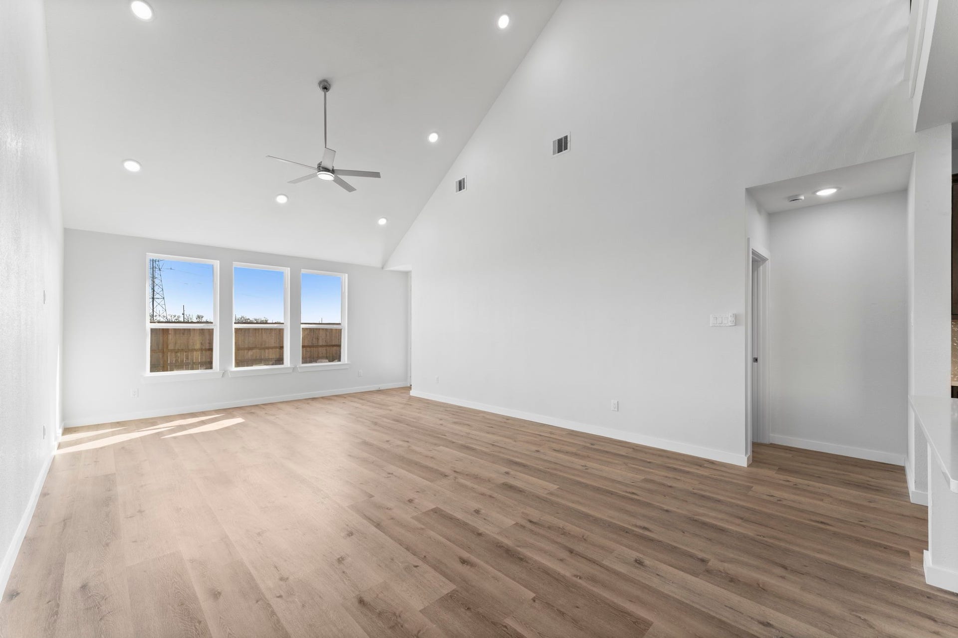 2230 Fresh Flower Way, Richmond, TX 77406 The main living area is a masterclass in scale, offering high ceilings, recessed LED lighting, and premium wide-plank flooring that runs throughout the home.