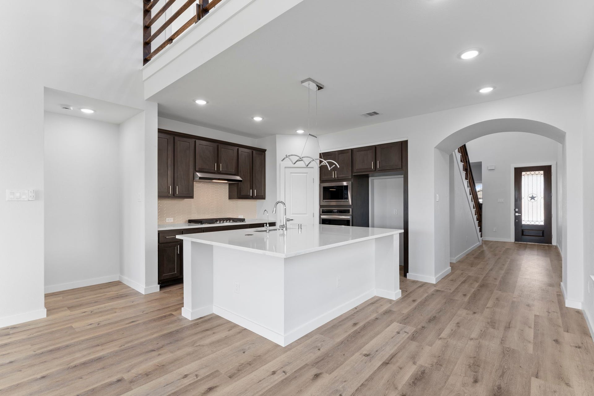 2230 Fresh Flower Way, Richmond, TX 77406 From this angle, see how the arched entryways and loft-style overlook add character and dimension to the main living space.