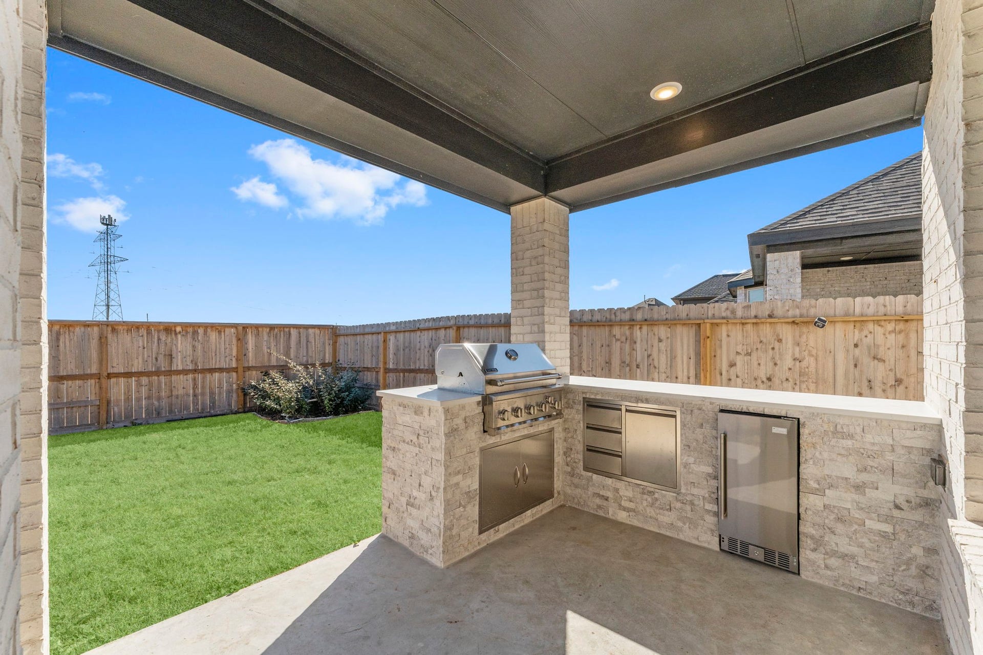 2230 Fresh Flower Way, Richmond, TX 77406 Entertain in style with this impressive covered patio featuring a built-in outdoor kitchen with a premium grill, storage, and refrigerator.