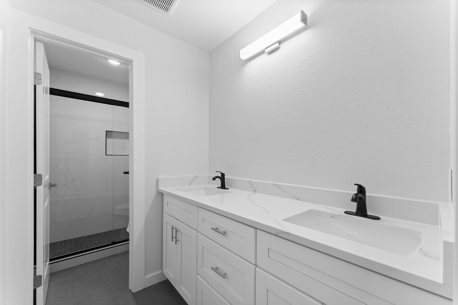 2230 Fresh Flower Way, Richmond, TX 77406 This secondary bath is finished with premium quartz vanities and designer matte black hardware.