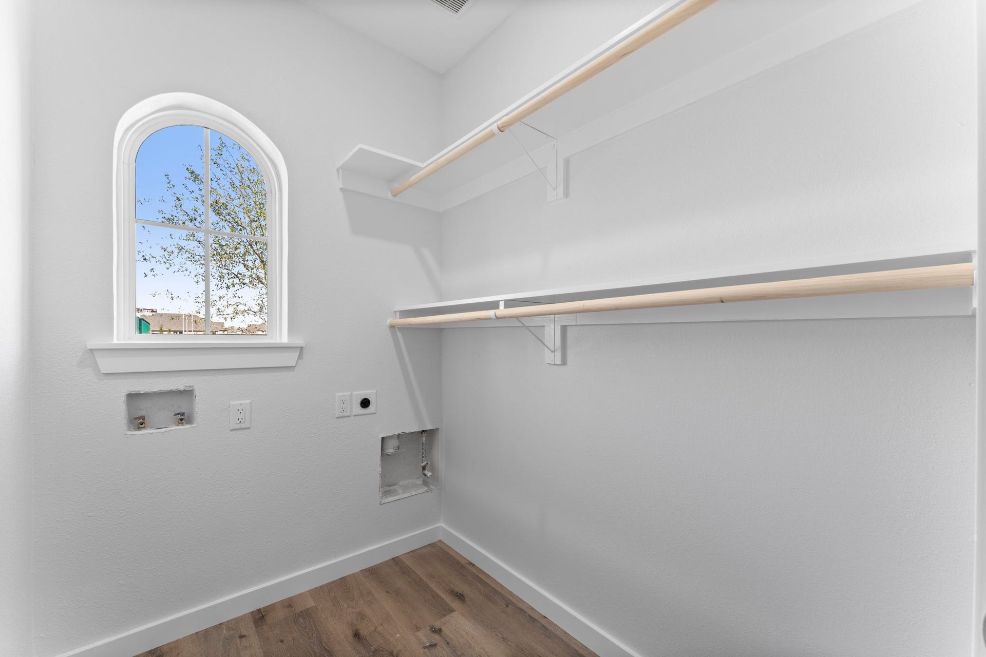 2230 Fresh Flower Way, Richmond, TX 77406 Organization Made Easy. This dedicated laundry and storage space comes equipped with sturdy built-in shelving and hanging rods, ensuring every inch of this home is maximized for a modern, organized lifestyle.