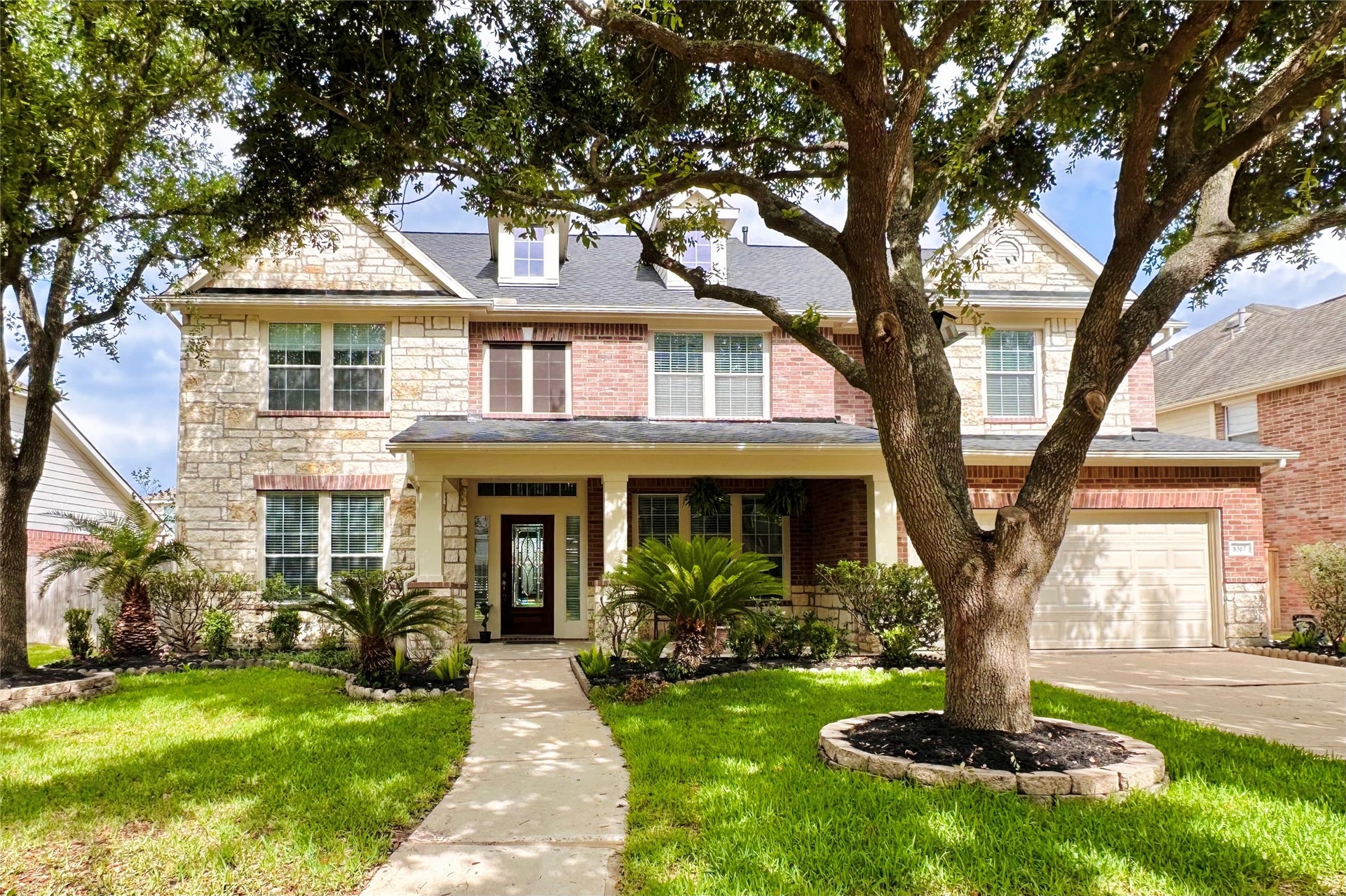 8307 Rosetrail Bend Lane, Katy, TX 77494 Discover this inviting two-story home with a timeless brick and stone exterior, charming front porch, and beautifully landscaped yard with mature trees.