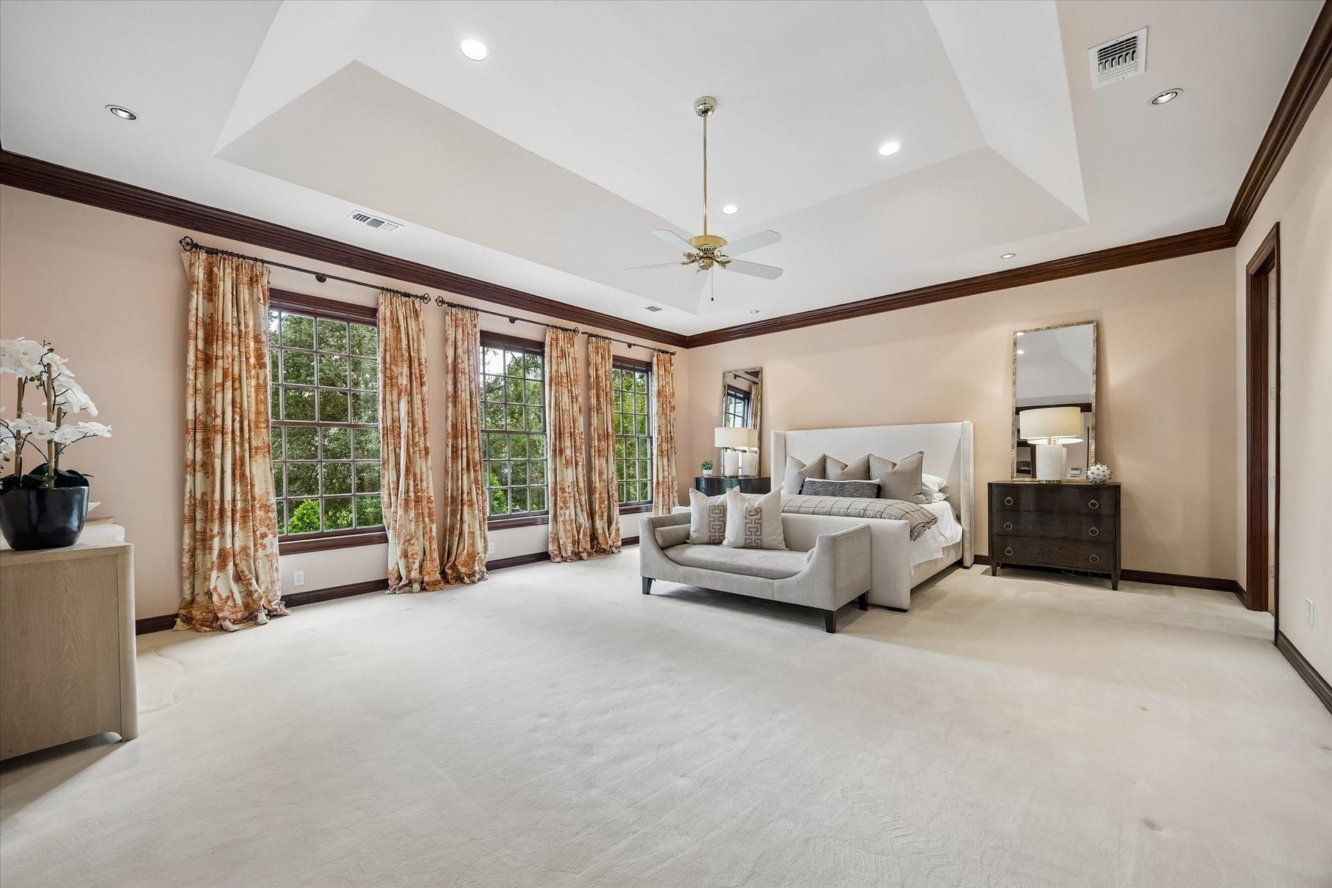 22 Eaton Square, Houston, TX 77027 The vaulted ceiling and wall of windows give the primary bedroom a light and airy feel.