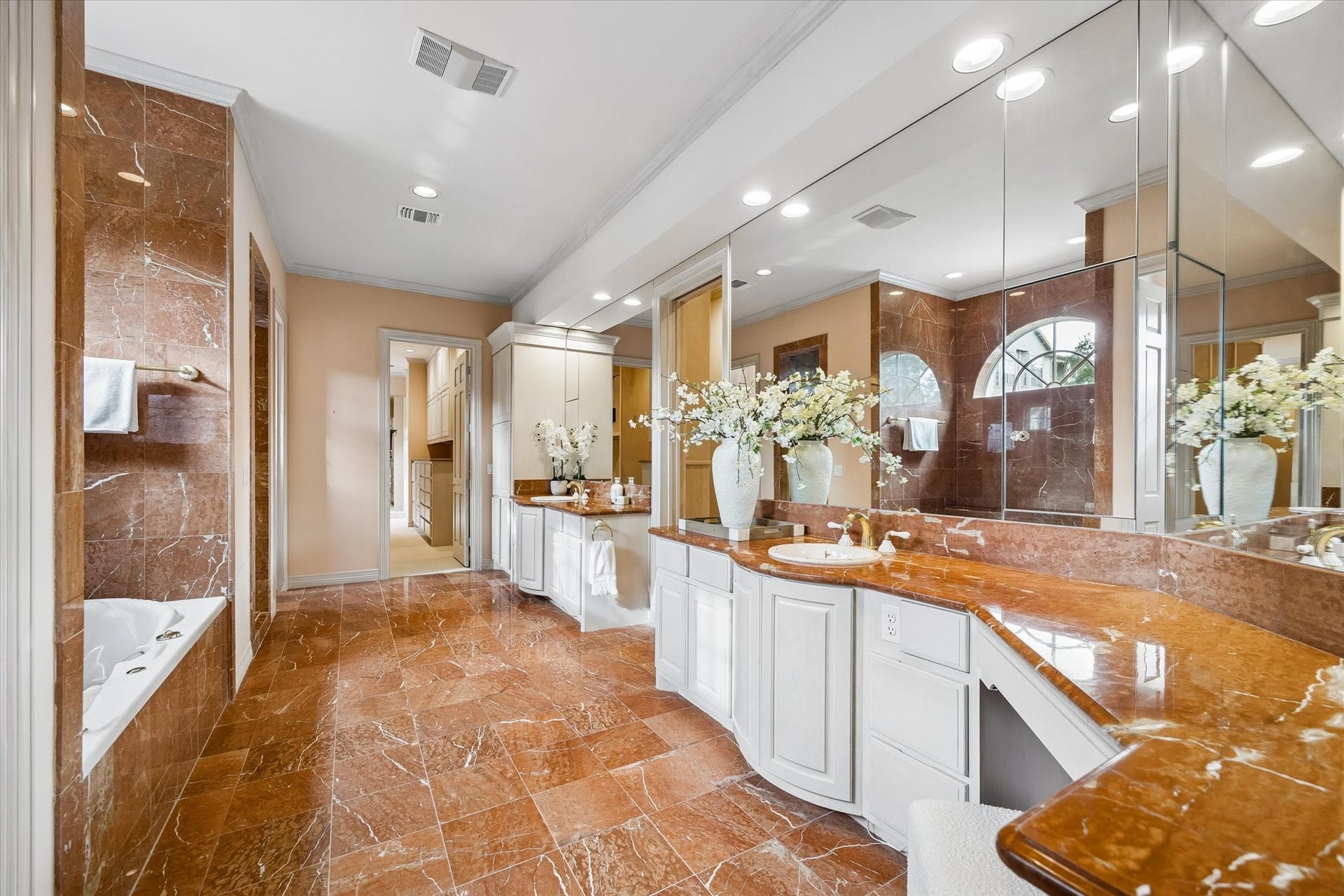 22 Eaton Square, Houston, TX 77027 A primary retreat including Royo Alicante marble quarried in the Alicante Province of Spain. Quintessential coral blossom double sinks, plus two water closets.