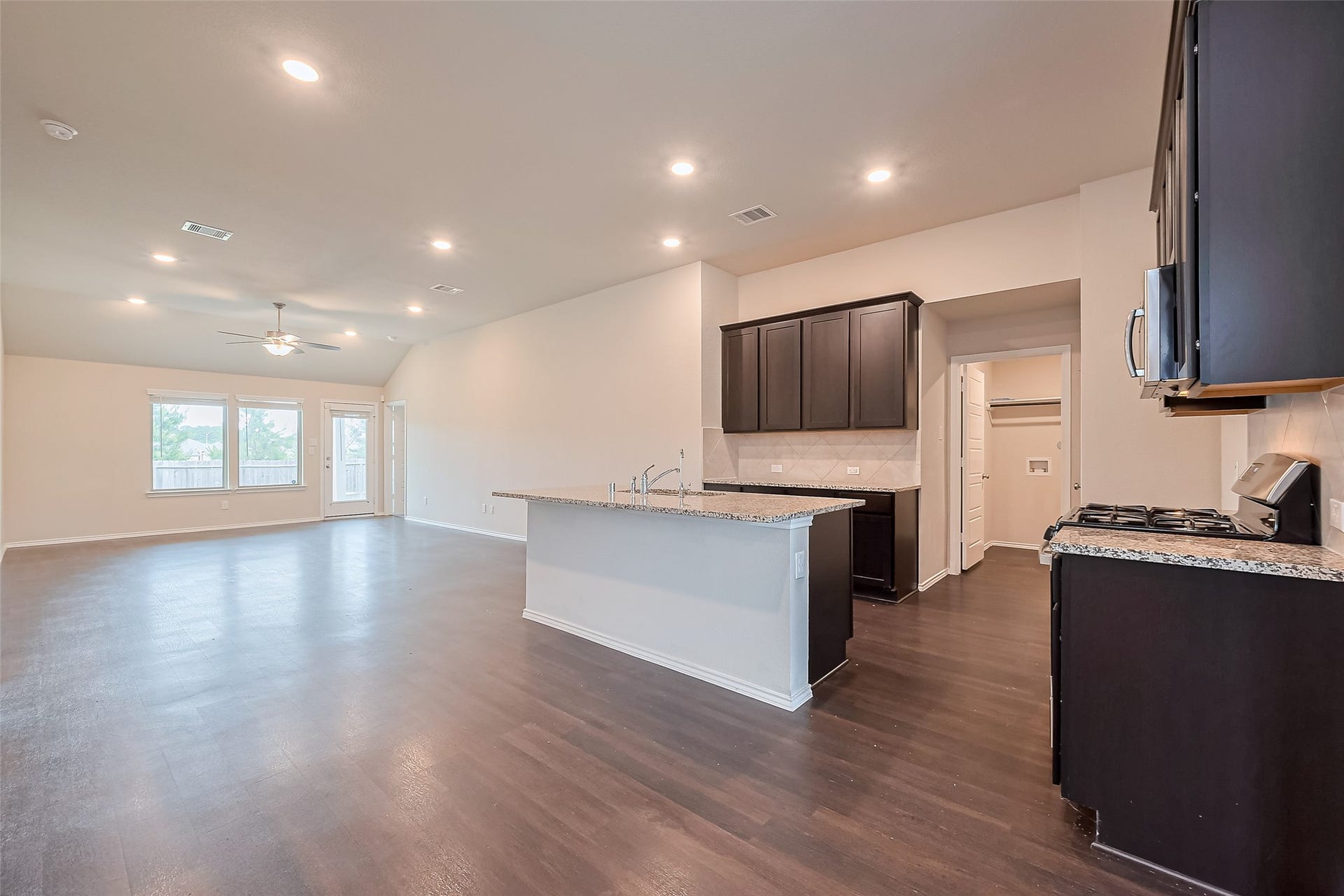 335 Jewett Meadow Drive, Magnolia, TX 77354 Open kitchen with granite counters, stainless appliances and gas range.