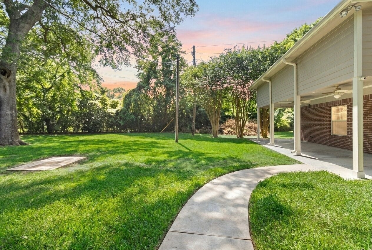 Follow the curved pathway through your private outdoor space where wide-open lawn areas & towering greenery create a calm, secluded setting.