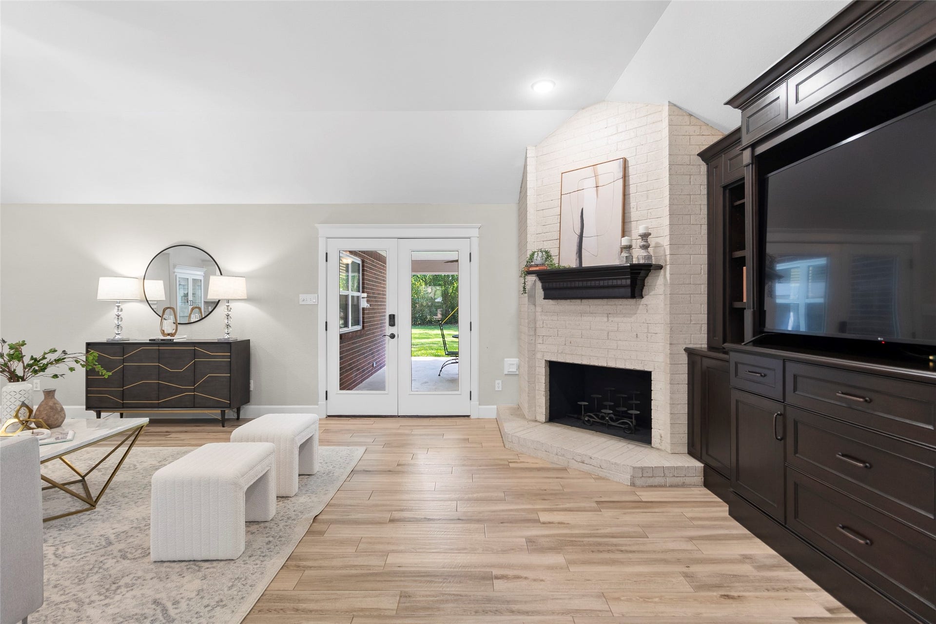 Imagine relaxing beside your stunning brick fireplace while natural light pours through the French doors leading to your covered outdoor retreat.