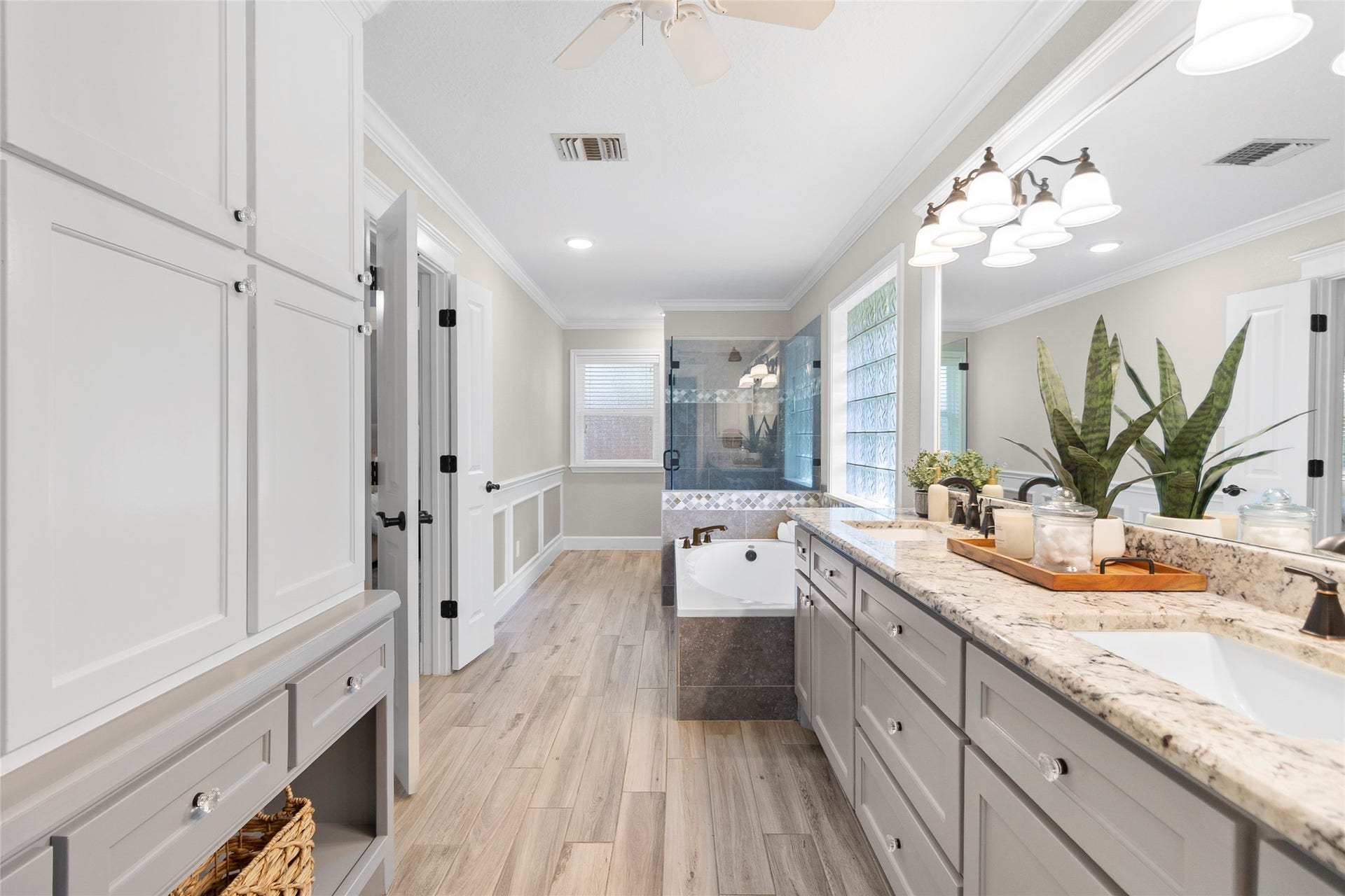 Start and end your day in a spa-inspired primary bathroom showcasing dual vanities, elegant finishes, abundant storage, and a beautifully designed soaking area.