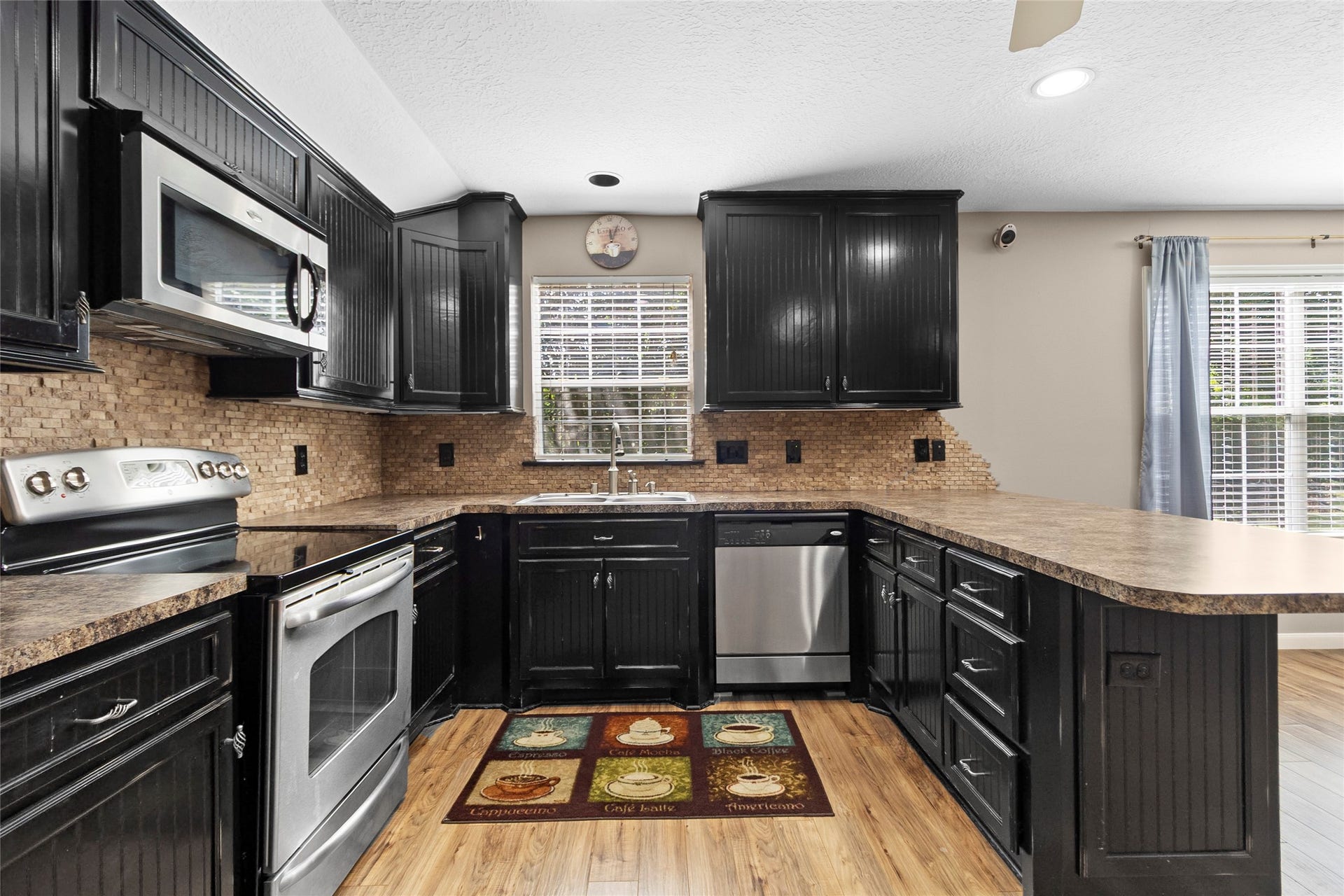 Cooking feels effortless in your beautifully updated kitchen featuring stainless steel appliances, abundant cabinetry, expansive prep space, and warm designer finishes throughout.