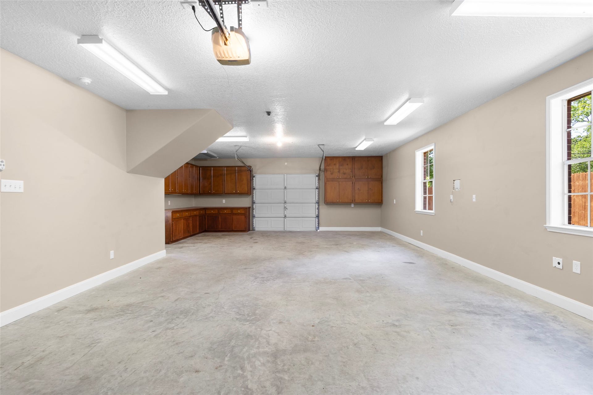 With generous room for vehicles, storage, tools, hobbies, or a workshop setup, this four-car tandem garage delivers the flexibility everyday life needs. Through access via a double-ended garage door makes loading and maneuvering easy, while insulated, sheetrocked walls and additional electrical hookups create a comfortable, functional space. A convenient half bath completes the setup.