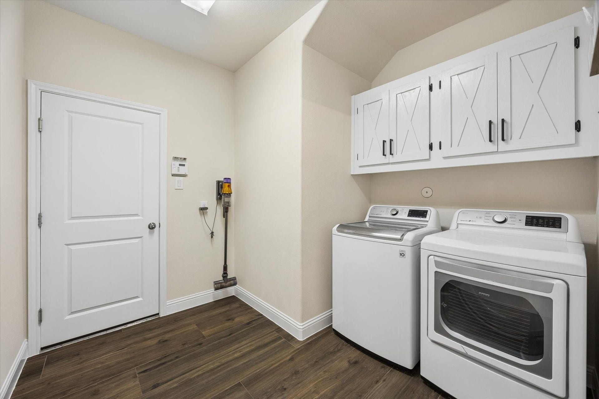 20338 Sienna Bluff Drive, Cypress, TX 77433 Convenient laundry room featuring more than enough room for a full-size washer and dryer, abundant overhead cabinetry, and durable flooring. The clean, neutral finishes and generous storage provide a practical and organized space for everyday household needs.