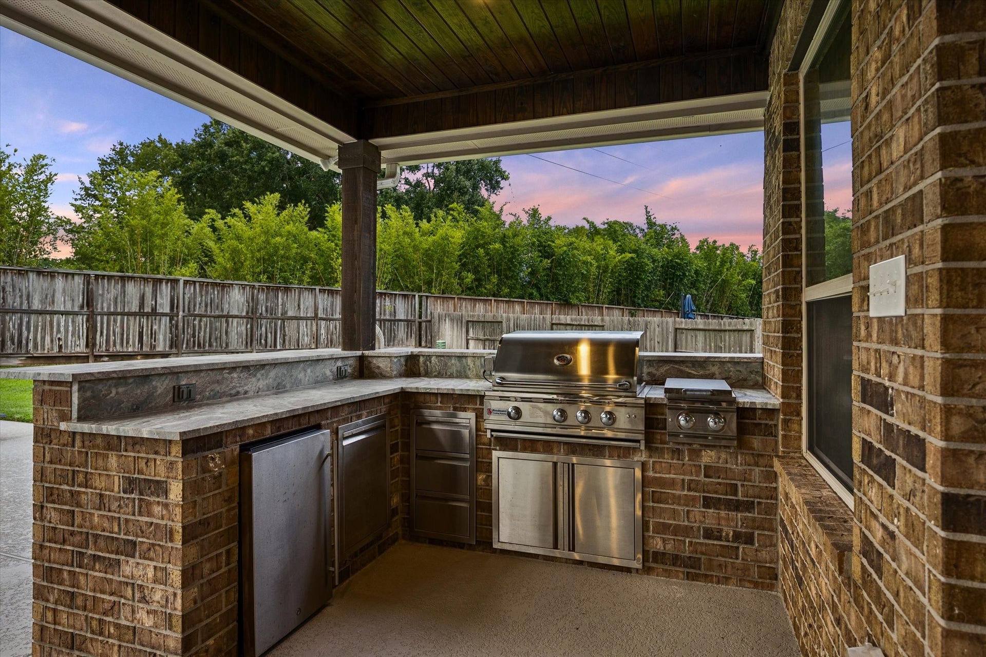 20338 Sienna Bluff Drive, Cypress, TX 77433 This impressive, covered kitchen features a built-in stainless-steel grill, side burner, refrigerator, and generous prep and serving space. This covered design provides shade and comfort for year-round gatherings with ample counter space that makes poolside dining and entertaining a breeze.