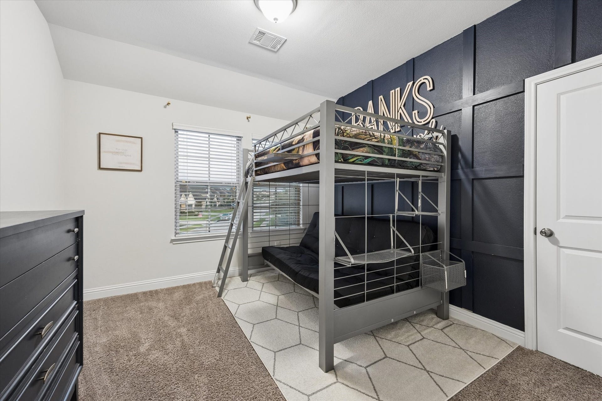 20338 Sienna Bluff Drive, Cypress, TX 77433 This charming bedroom combines function and personality with a bold navy board-and-batten accent wall that creates a striking focal point.