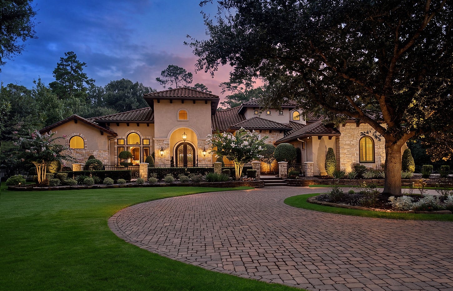 119 S Tranquil Path, The Woodlands, TX 77380 Set among the mature trees and timeless beauty of Grogans Point, this exceptional estate makes a striking first impression with its grand architectural presence, lush landscaping, and beautifully crafted exterior. A sweeping paver drive leads to an inviting entrance framed by stone, stucco, and elegant arched details, creating a sense of understated luxury from the moment you arrive.