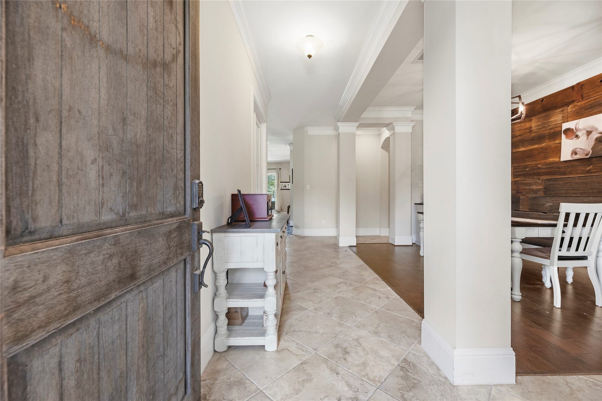 5414 Lake Hill Farm Way, Fulshear, TX 77441 Welcoming entry foyer with a heavy solid-wood front door, large-format diagonal tile flooring, high ceilings with crown molding, decorative archways, and supporting accent columns.
