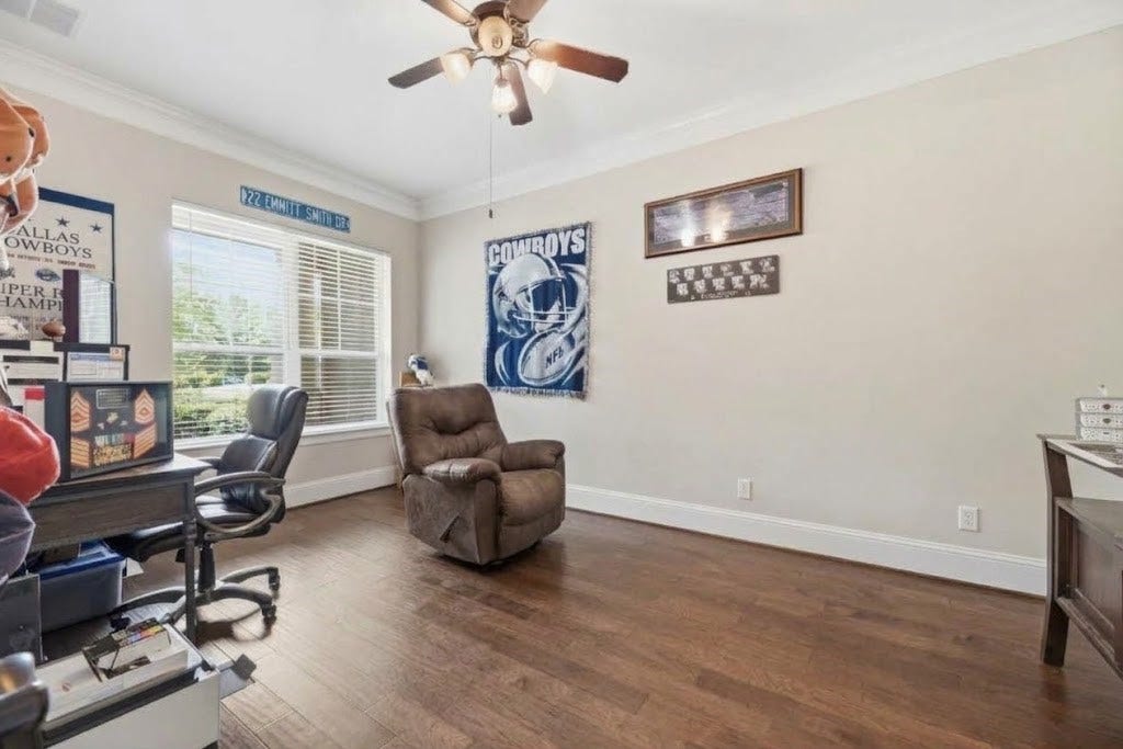 5414 Lake Hill Farm Way, Fulshear, TX 77441 Dedicated study featuring rich dark wood-look flooring, crown molding, a central ceiling fan with light fixture, high baseboards, and large front-facing windows with blinds.