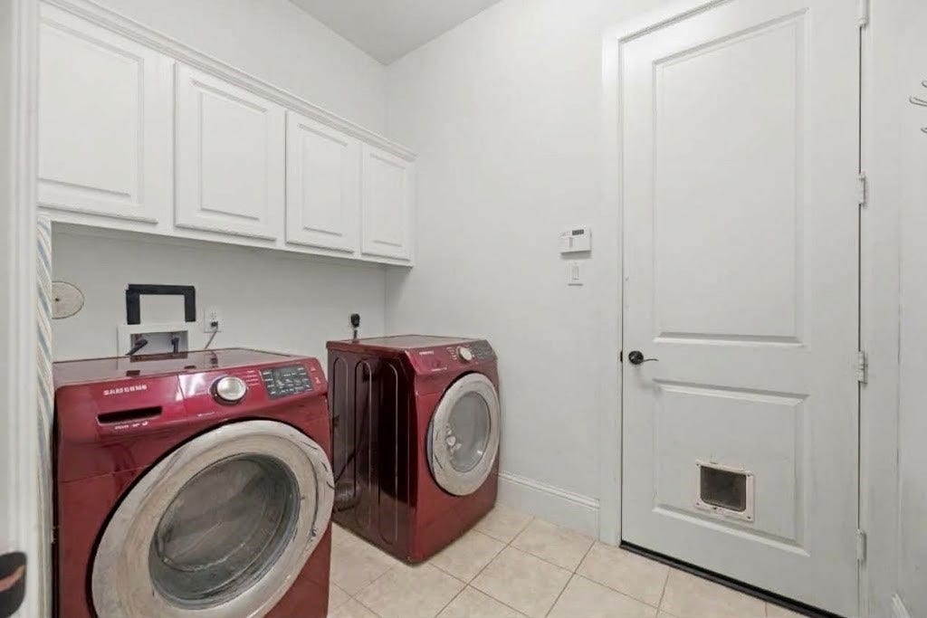 5414 Lake Hill Farm Way, Fulshear, TX 77441 Dedicated utility room with tile flooring, built-in upper storage cabinets in white, baseboards, and an exterior side/garage access door with an integrated pet door.