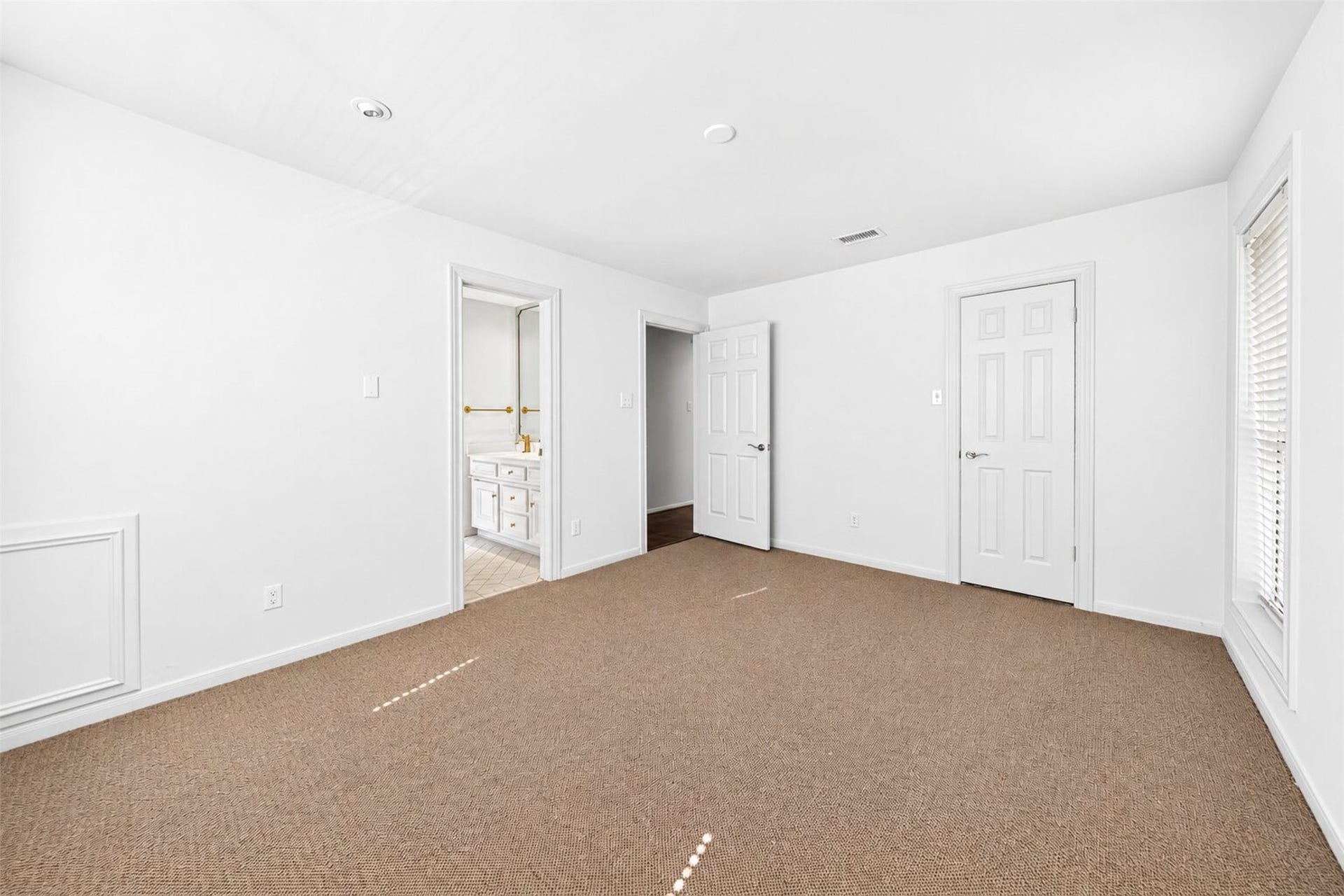 Reverse bedroom view shows the closet door and opening to the adjoining vanity area.