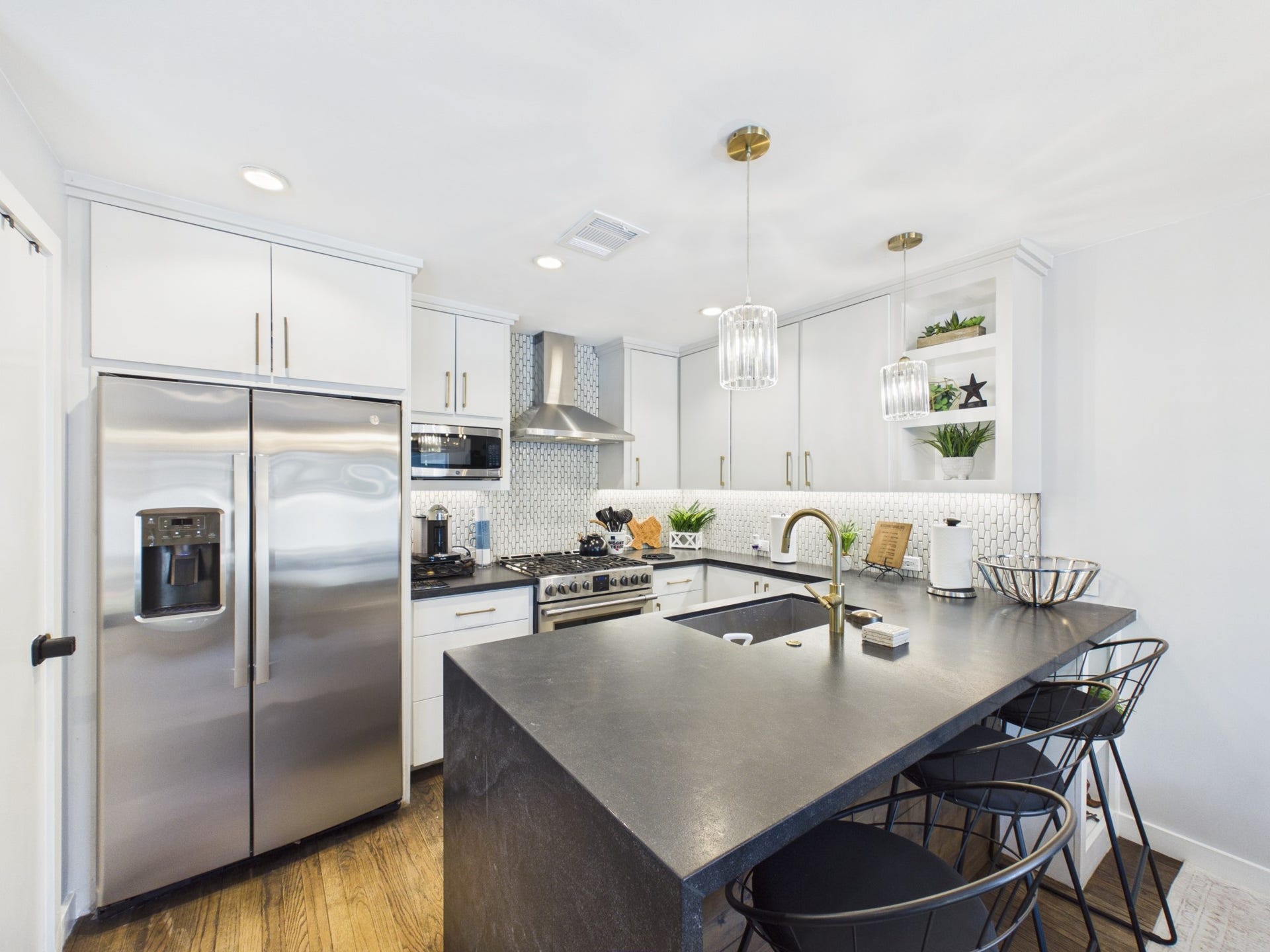 Sleek Kitchen with Black Granite Counters, Stainless Steel Appliances and White Cabinets w/Brass Accessories