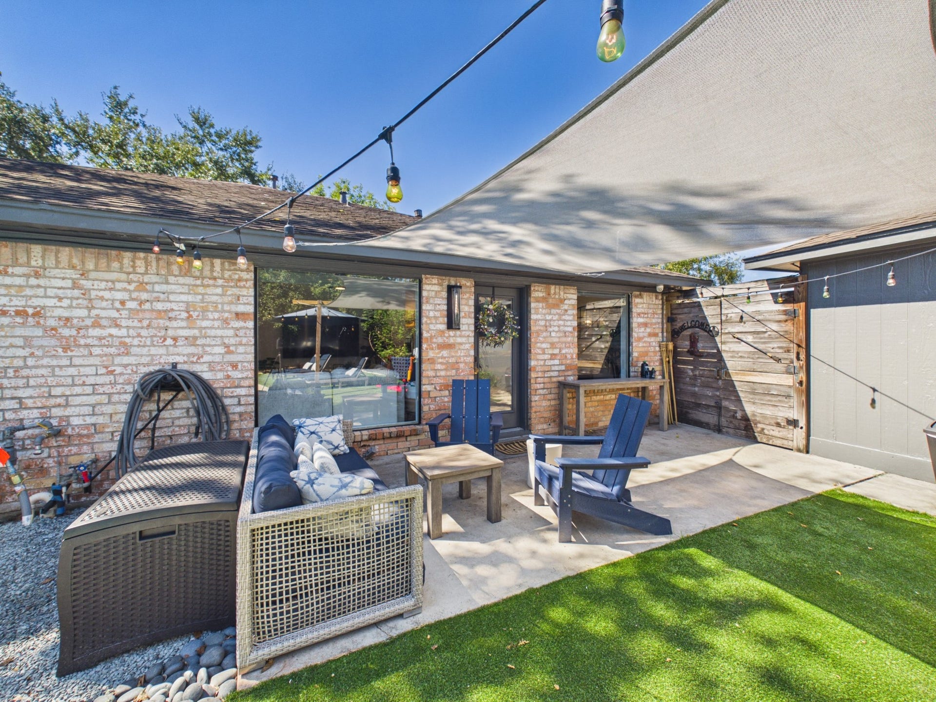 Resort Style Backyard with Shaded Patio, Couch and Adirondack Chairs