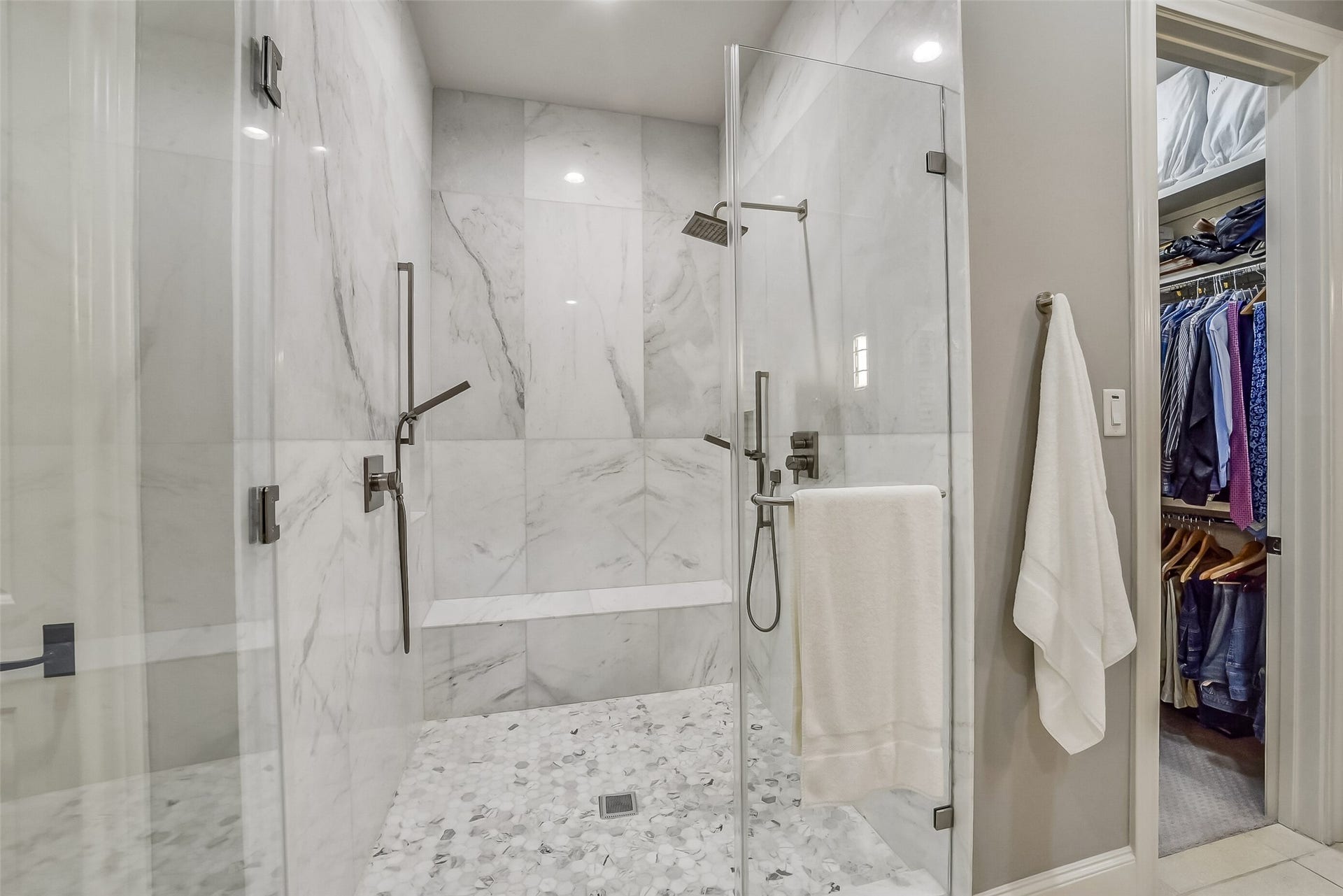 11 Southside Circle, Southside Place, TX 77025 Beautiful walk-in shower showcases frameless glass enclosure and a built-in bench for added comfort and convenience. Dual shower fixtures, including a rainfall showerhead and handheld sprayers, complement the sophisticated design.