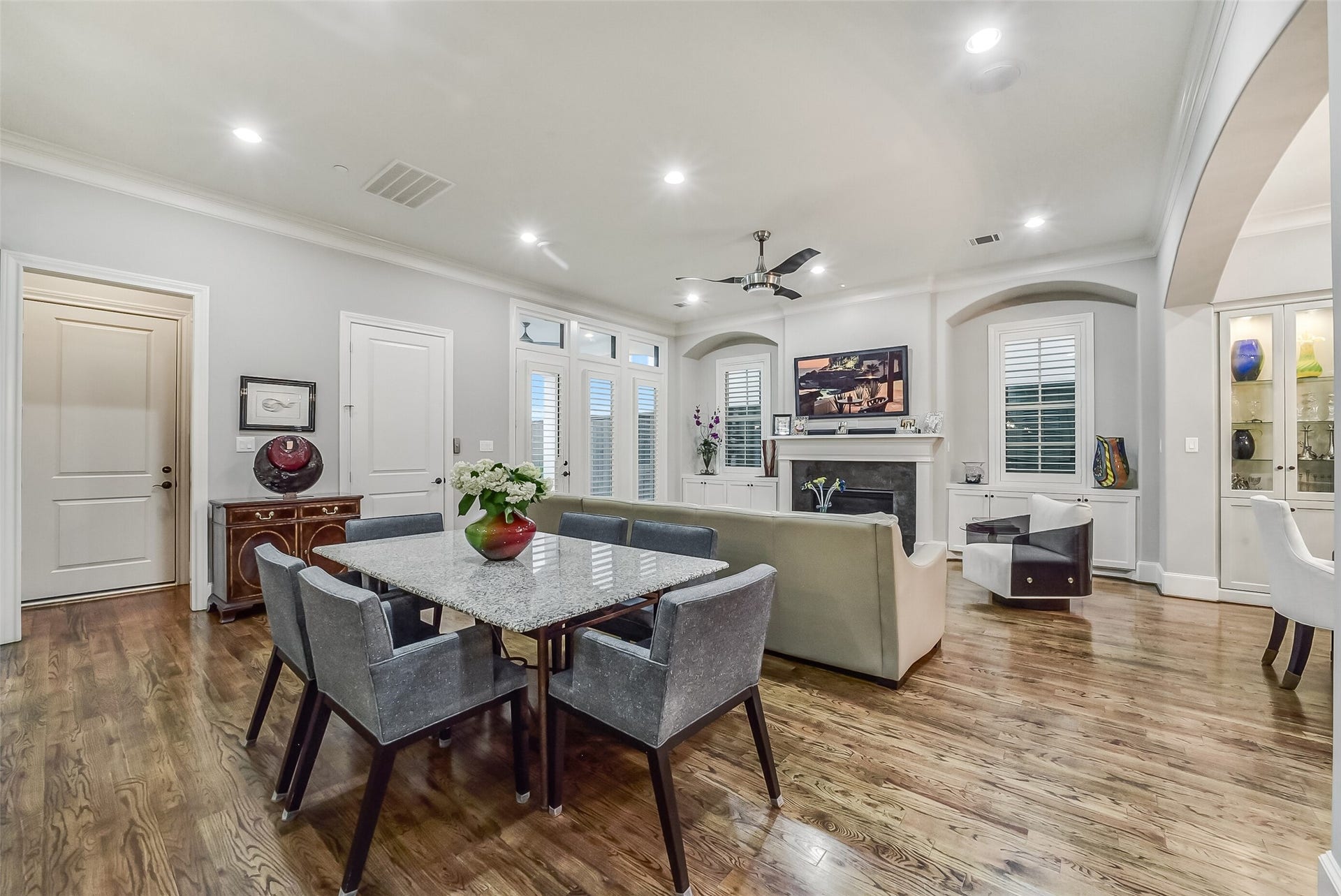 11 Southside Circle, Southside Place, TX 77025 Perfectly positioned casual dining area between the kitchen and living spaces. This alternate view also showcases charming wood shutters and built-in cabinetry on either side of the living room fireplace.