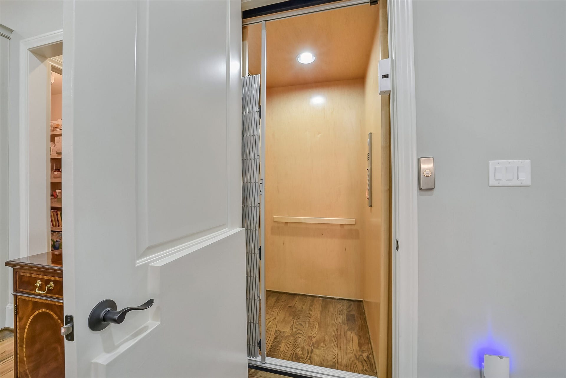 11 Southside Circle, Southside Place, TX 77025 Convenient in-home elevator with warm wood paneling, a hardwood floor, and a collapsible gate, making it easy to move between levels with luggage, or laundry. It also adds long-term accessibility and everyday ease.