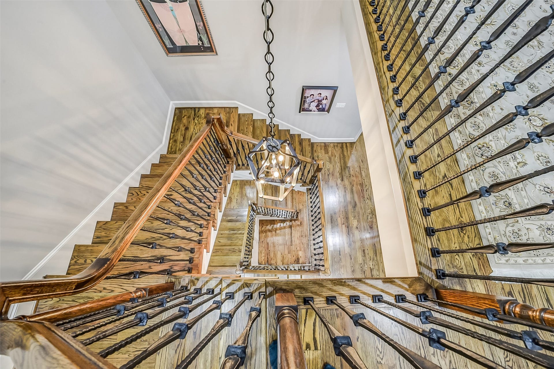 11 Southside Circle, Southside Place, TX 77025 Striking perspective looking down the multi-level staircase, showcasing the rich hardwood treads, intricate wrought-iron and wood railings, and the home's exceptional vertical architectural flow.