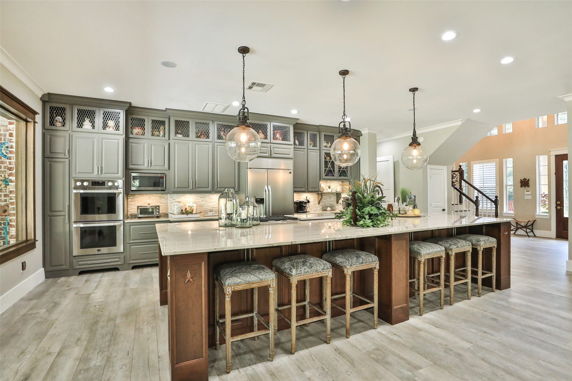 For the culinary enthusiasts, equipped with top-of-the line LG Studio appliances, solid wood cabinets, breakfast bar, wood look tile floors and Pottery Barn Pendants. Island has 3 retractable pop up power sockets.