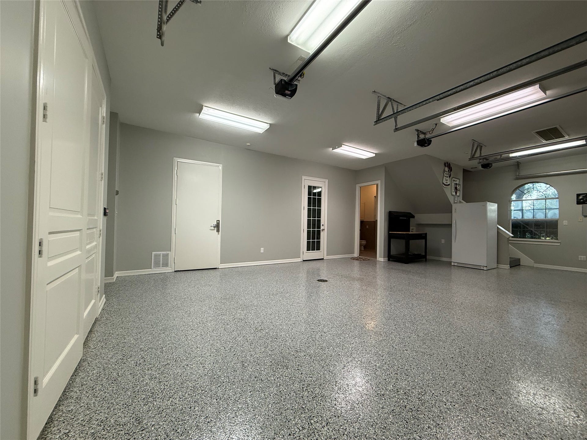 The 3-car, air-conditioned garage is far more than a place to park. Finished with durable epoxy flooring, bright overhead lighting, and recently replaced garage door openers on all three overhead doors, this space is ideal for car enthusiasts, hobbyists, or anyone needing a clean, versatile workspace. It also features a safe room and a full bathroom, adding both convenience and peace of mind. Whether you're storing a prized collection, creating the ultimate workshop.