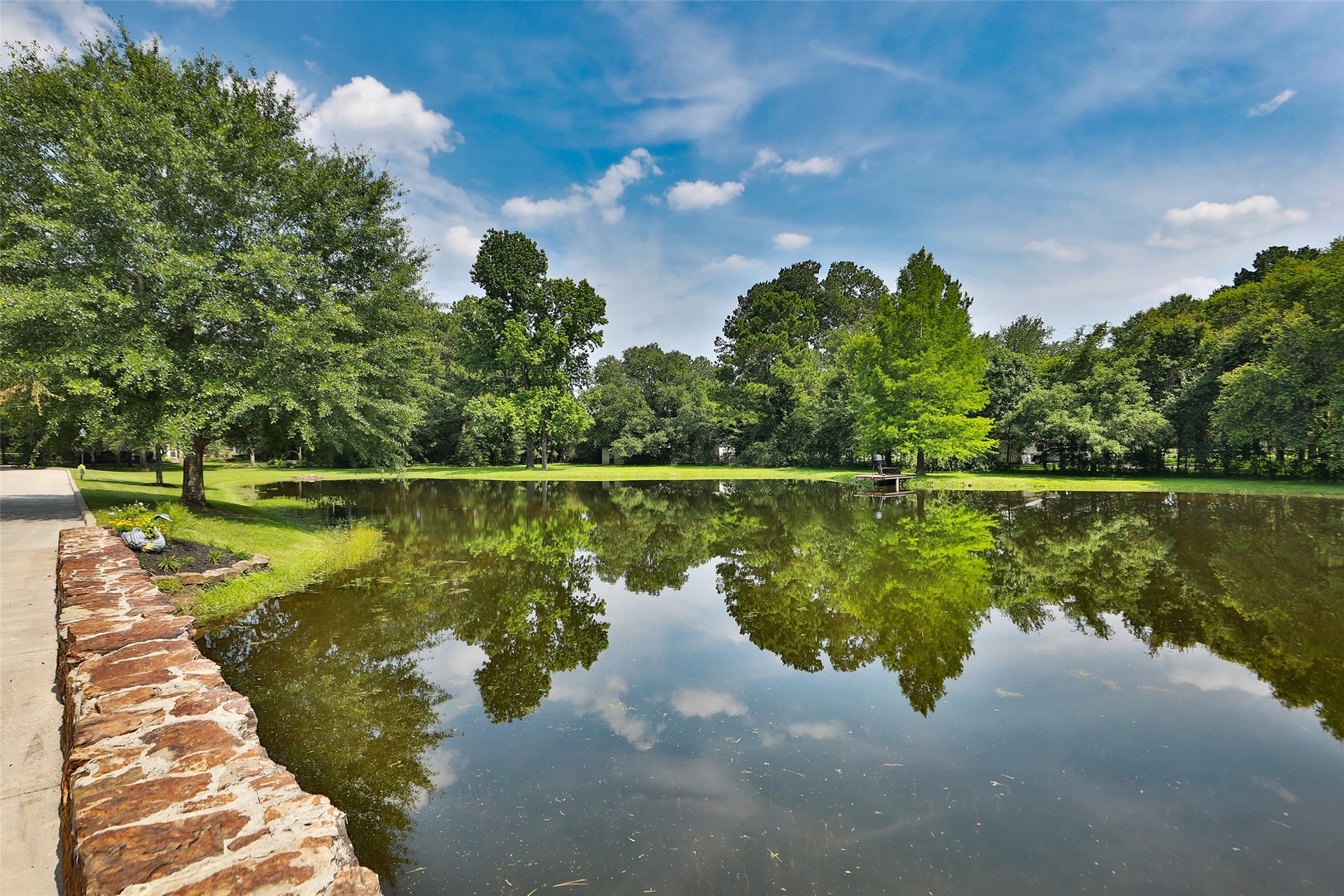Imagine coming home every day to this breathtaking view! As you cross the charming stone bridge overlooking your private stocked pond, you're welcomed by the beauty and tranquility of your own estate. This isn't just a drivewayit's an unforgettable entrance to a place you'll love calling home!