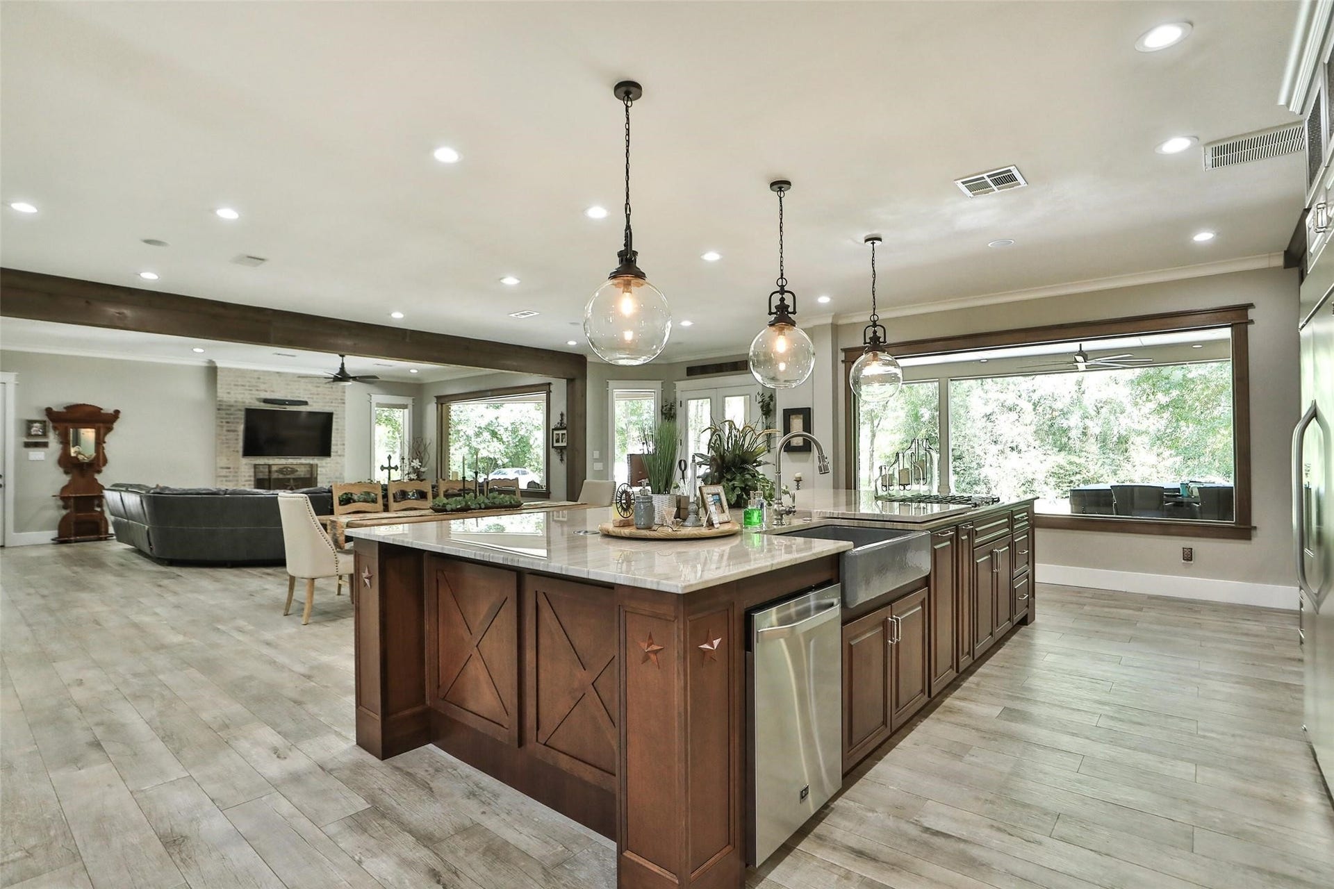 Natural light pours in through the expansive picture window, which frames views of the covered patio, outdoor living area, and hot tubcreating a seamless connection between indoor and outdoor entertaining. Open to the surrounding living spaces, this impressive kitchen is designed for both everyday living and hosting unforgettable gatherings.