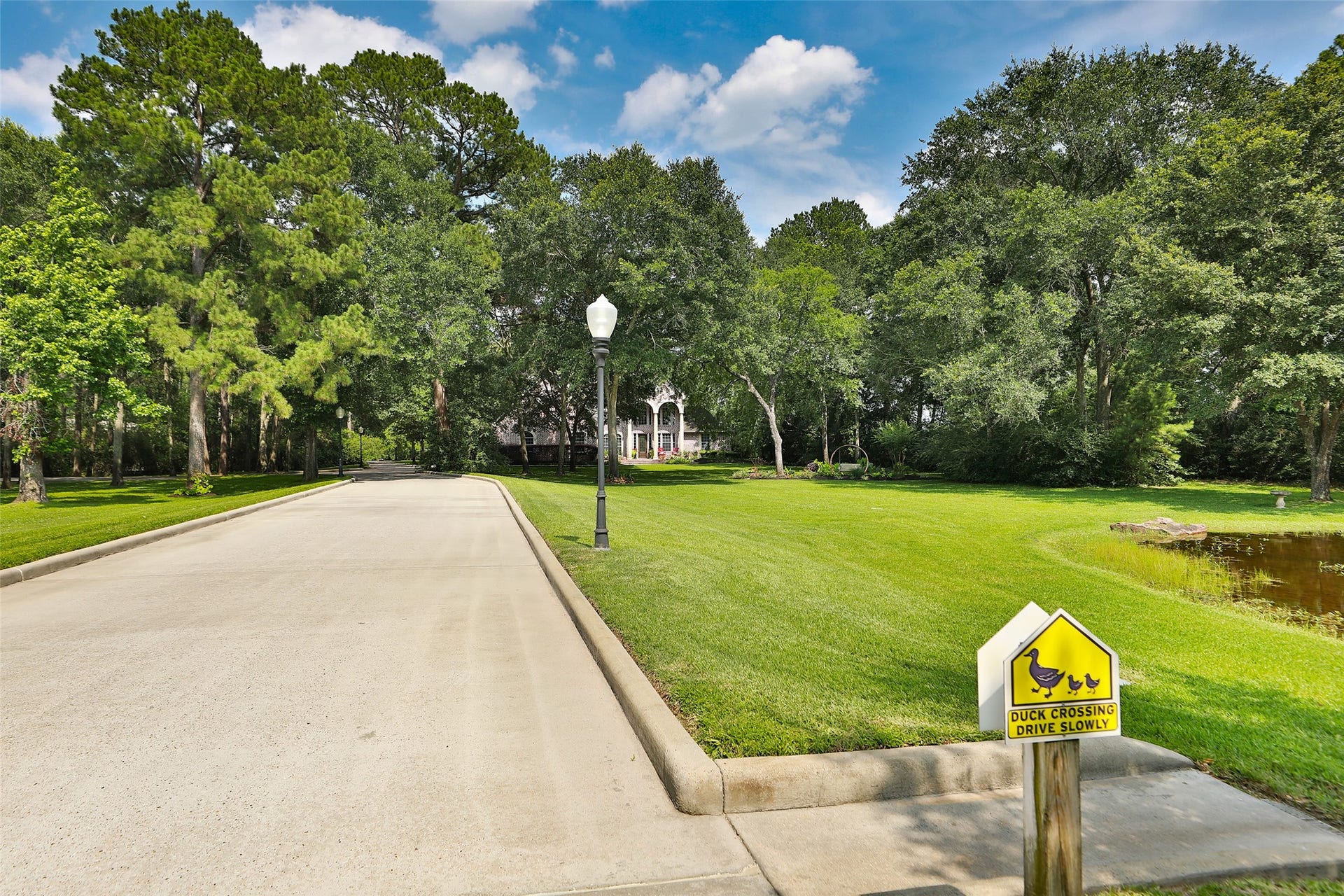 Experience a grand arrival as you cross the picturesque stone bridge and follow the light-lined driveway leading to a stunning custom-built home. Every turn welcomes you with beauty, charm, and a sense of arriving somewhere truly special!