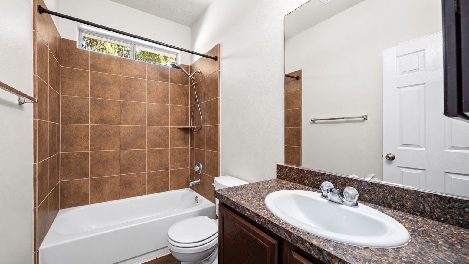 11246 Glenforest Drive, Montgomery, TX 77356 Convenient full bathroom featuring a tub and shower combination with attractive tile surround, spacious vanity, and natural light.