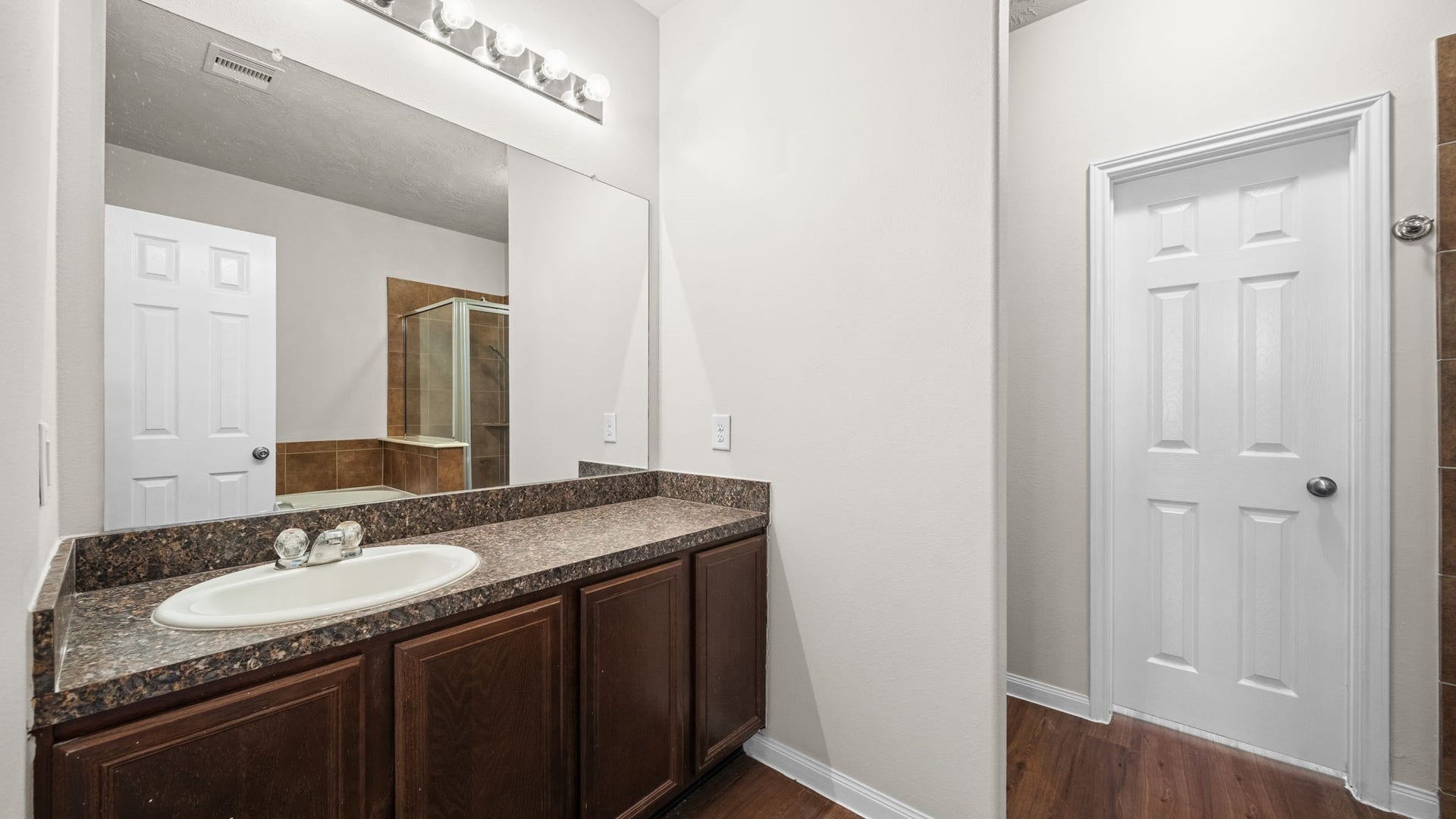 11246 Glenforest Drive, Montgomery, TX 77356 Start your mornings with ease in this inviting primary bathroom featuring a spacious vanity, generous countertop space, and rich wood cabinetry for convenient storage.