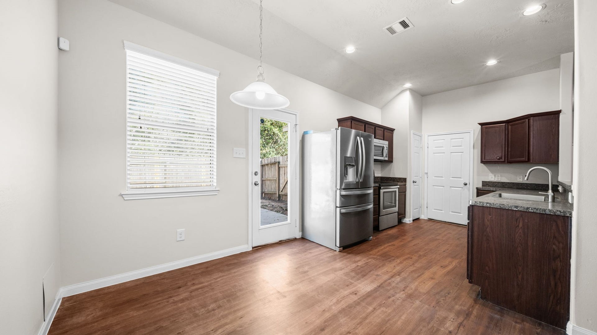 11246 Glenforest Drive, Montgomery, TX 77356 Bright and welcoming dining space with beautiful wood-look flooring, pendant lighting, and easy access to the backyard.