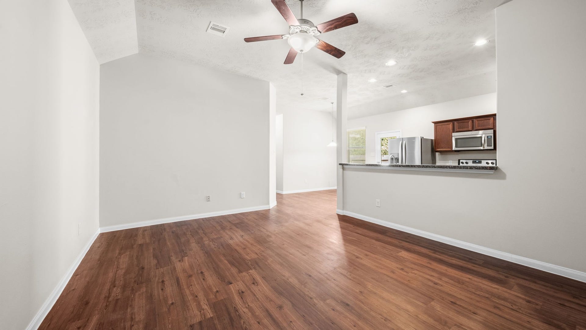 11246 Glenforest Drive, Montgomery, TX 77356 Step inside to discover an inviting open-concept living space with soaring ceilings, warm wood-look flooring, and seamless flow into the kitchen and dining areas.